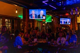 People watch the presidential debate between President Joe Biden and former President Donald Trump at Shaw’s Tavern in Washington, June 27.