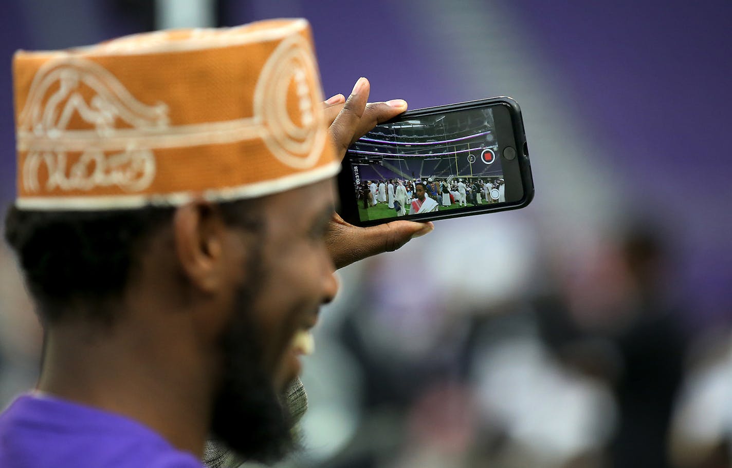 Muslim worshiper photographs the impressive setting Tuesday, Aug. 21, 2018, at U.S. Bank Stadium in Minneapolis, Minn. To celebrate Eid ul-Adha, the organization Super Eid hopes to bring together over 50,000 Muslims to pray. (David Joles/Minneapolis Star Tribune/TNS) ORG XMIT: 1238675