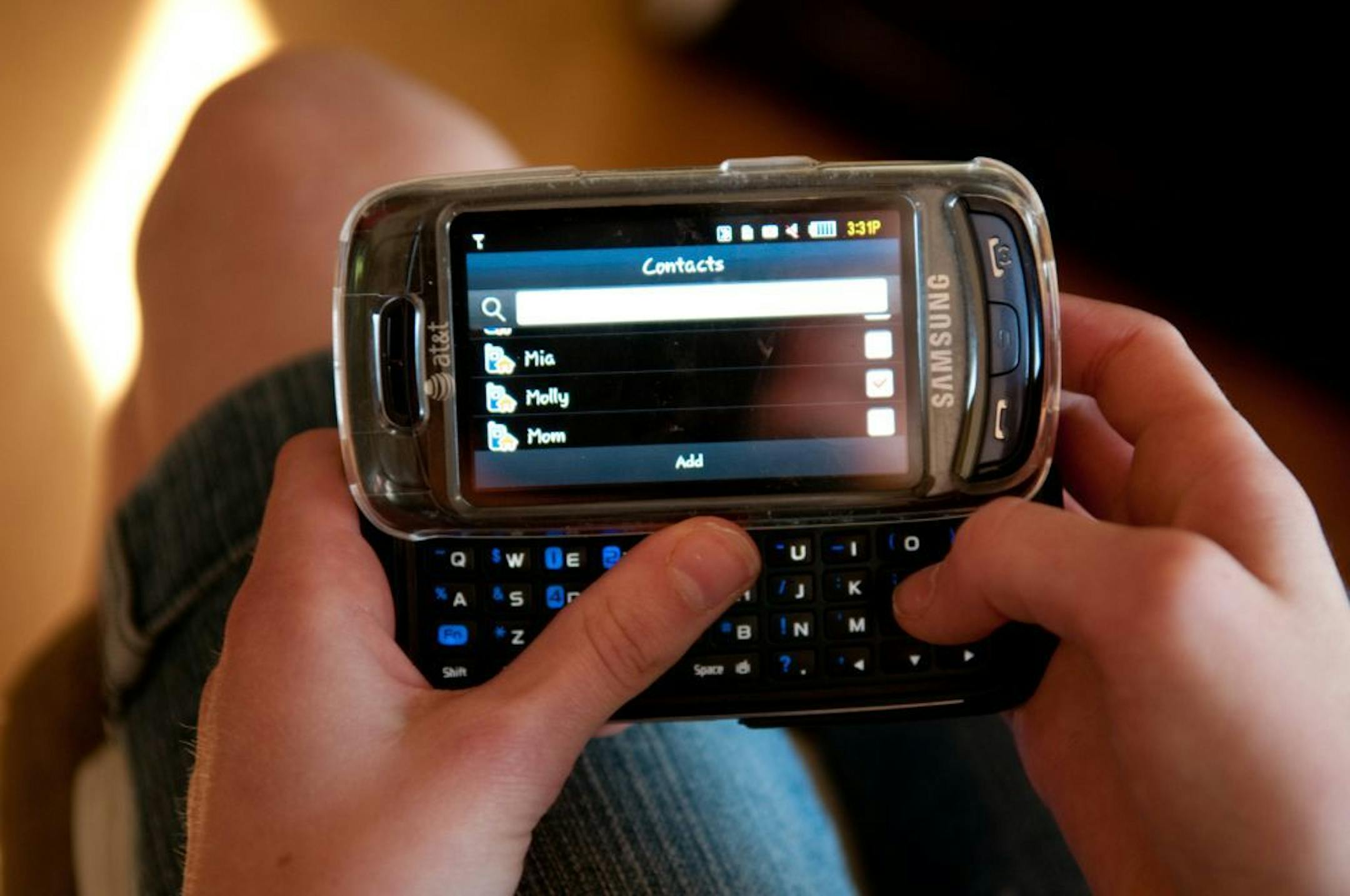 A teenager (who is awake) composes a text message on her cell phone.