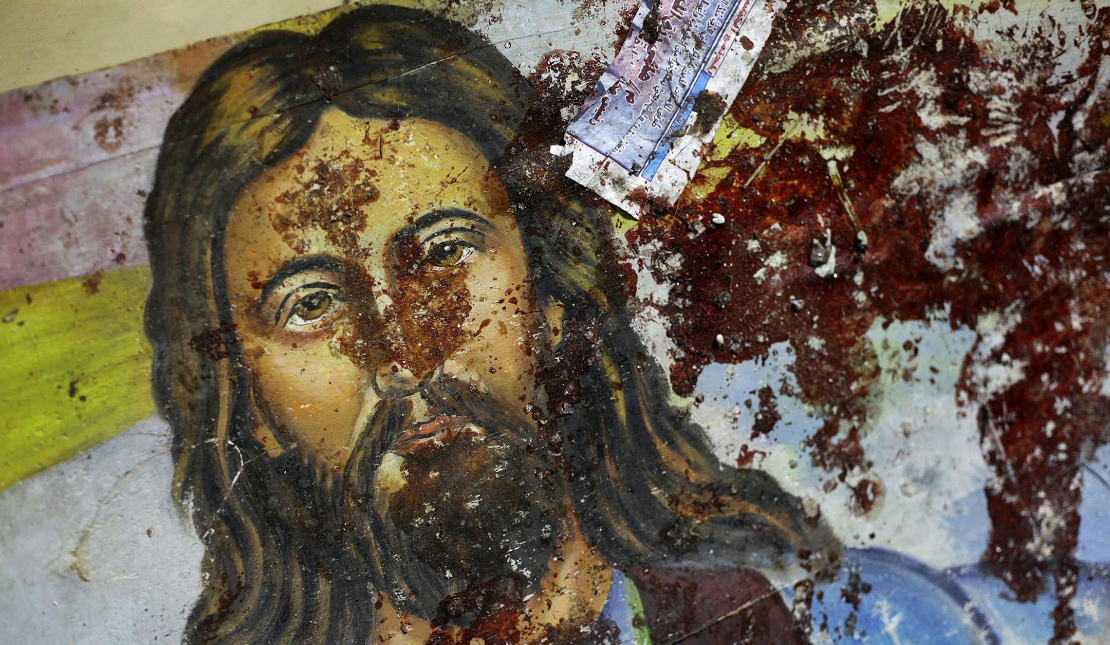 A blood-spattered poster of Jesus Christ is seen inside the the Coptic Christian Saints Church in the Mediterranean port city of Alexandria, Egypt Saturday, Jan. 1, 2011. A car exploded in front of the church early Saturday as worshippers emerged from a New Year's Mass, killing at least 21 people according to officials, and sparking clashes between Christians and Muslims _ a sign of the sectarian anger that has been arising with greater frequency in Egypt. (AP Photo/Ben Curtis) ORG XMIT: MIN2015