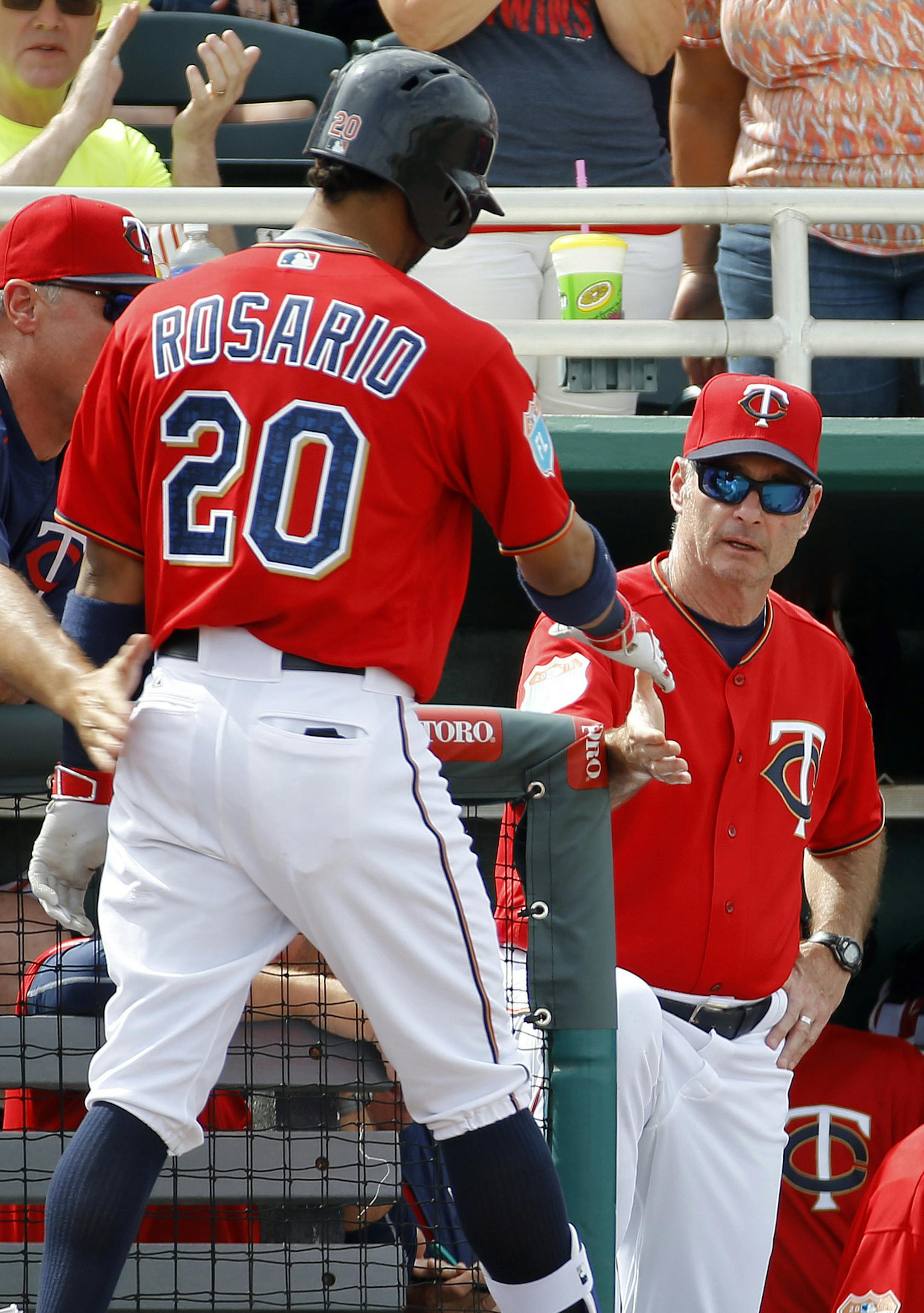 Minnesota Twins manager Paul Molitor, center, greets Eddie Rosario after his solo home run in the fourth inning of a spring training baseball game against the Baltimore Orioles in Fort Myers, Fla., Saturday, March 5, 2016. (AP Photo/Patrick Semansky)