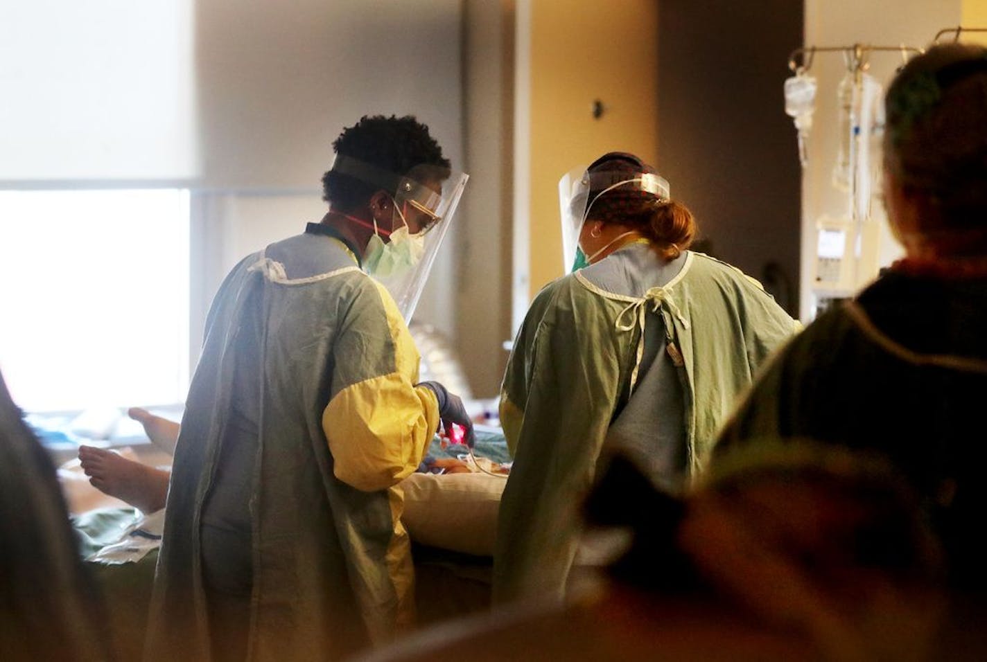 Health care workers monitored a COVID-19 patient on the third floor ICU at Bethesda Hospital in St. Paul.