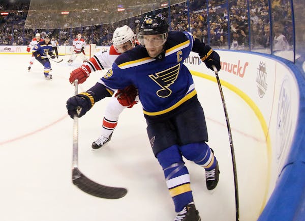 St. Louis Blues center David Backes holds off the stick of Carolina Hurricanes center Jay McClement in the third period of an NHL hockey game Thursday