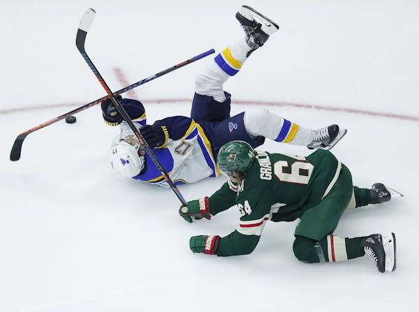 St. Louis Blues left wing Jaden Schwartz, (17) lands on the ice after colliding with Minnesota Wild right wing Mikael Granlund (64) during the third p