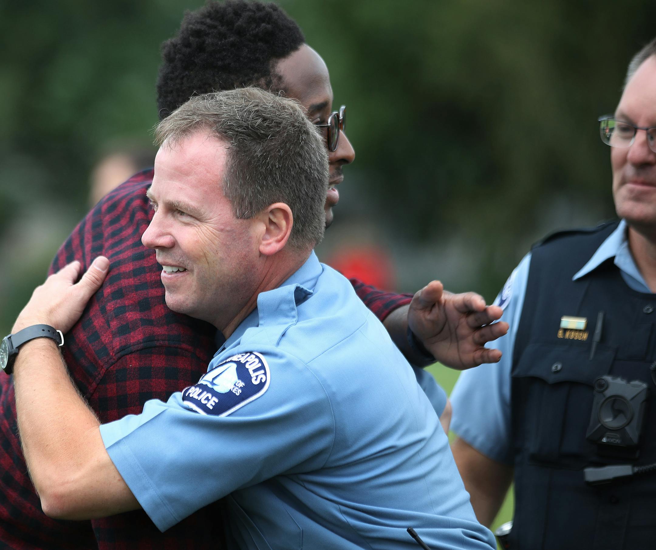 Tim Harris hugged Minneapolis officer Dean Milner at Minnehaha Academy on the anniversary of the explosion that rocked the school Thursday Aug. 2, Minneapolis. Milner and officer Greg Kosch were the first on the scene a year ago.