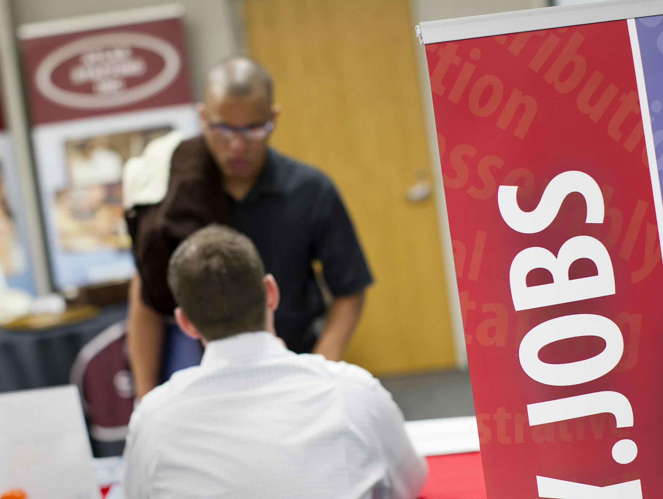 Representatives from companies hiring locally speak with guests at the Job Development Career Fair at Brookdale Library in Brooklyn Center December 7, 2015. (Courtney Perry/Special to the Star Tribune)