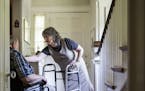 Gail Schwartz, 78, helps her husband David, 85, out of his wheelchair at their home in Chevy Chase, Md., July 1, 2015. A rising reality for many elder