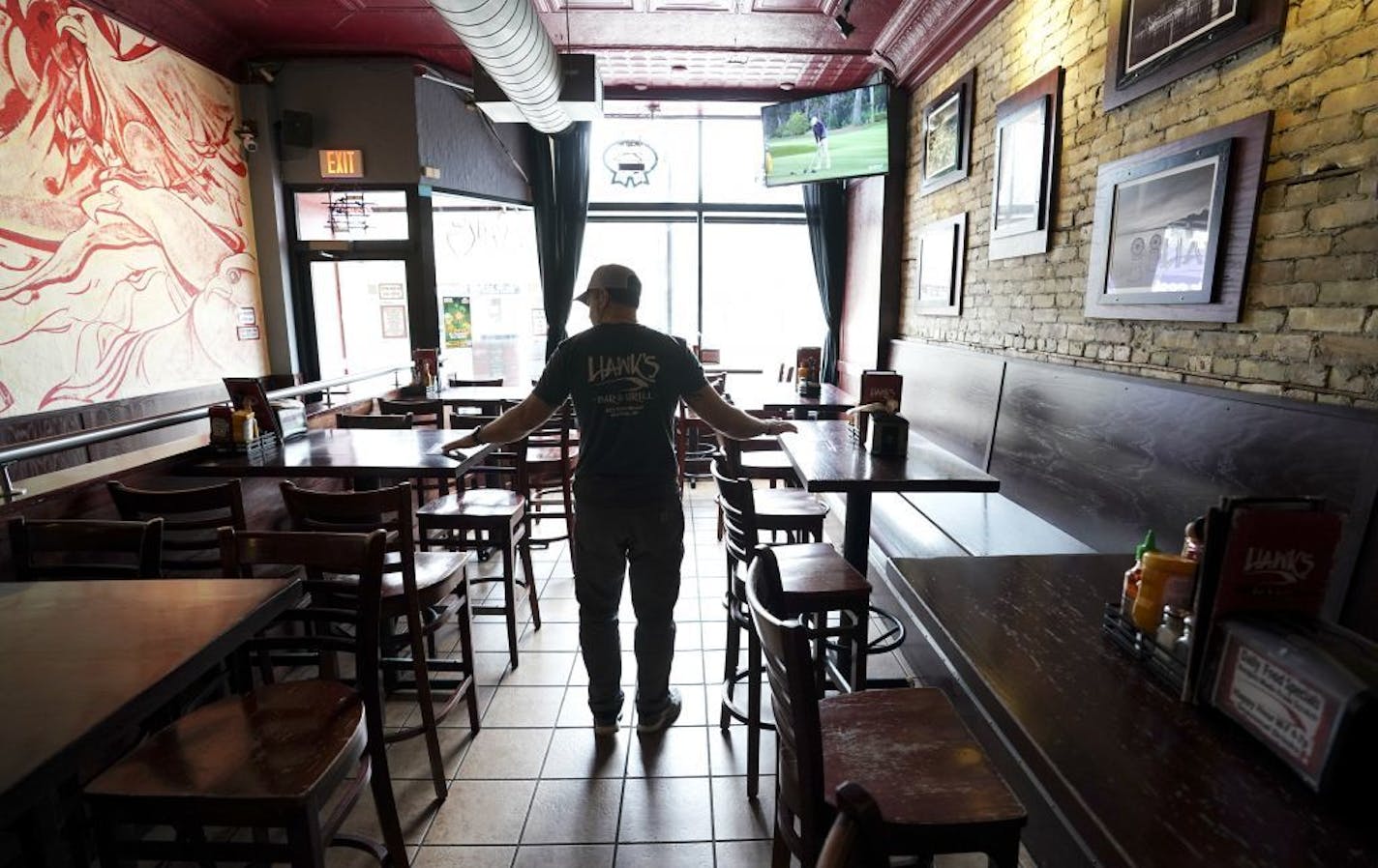 Hawk Sullivan, owner of Hawks Bar & Grill on State Street is photographed Monday, March 16, 2020 over the lunch hour in his empty restaurant in Madison, Wisc. Wisconsin Gov. Tony Evers on Monday ordered a ban on all gatherings of more than 50 people, a dramatic move in line with federal recommendations and as other states took similar action to stop the spread of the new coronavirus.