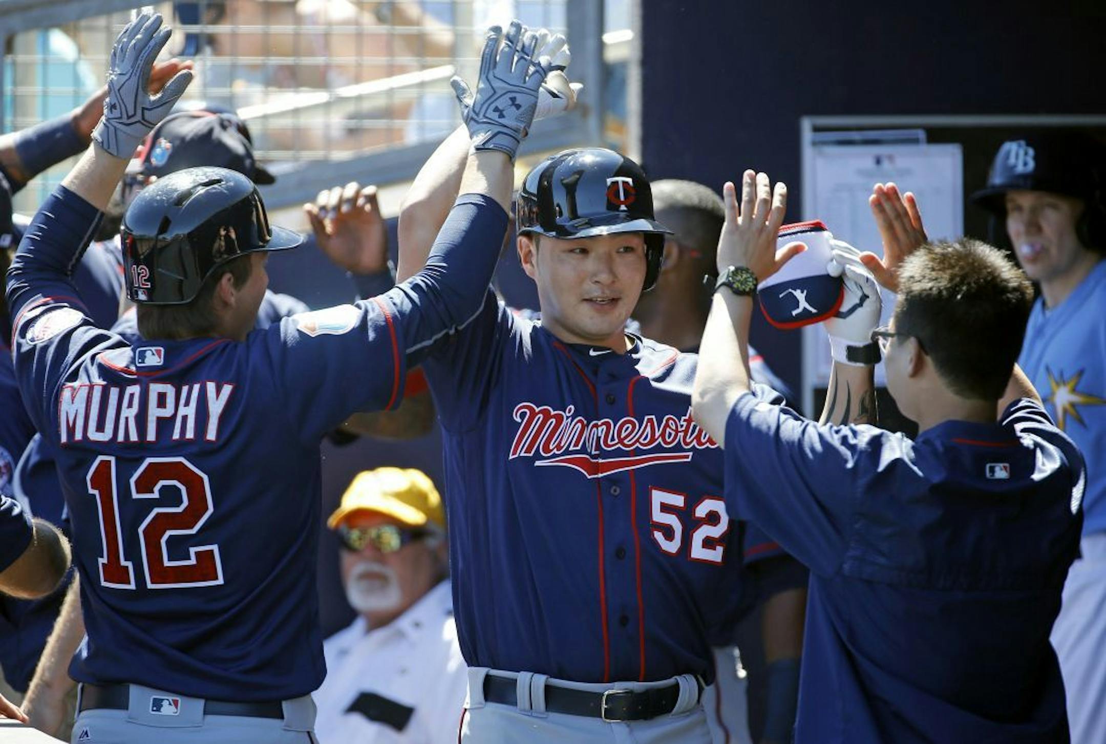Minnesota Twins' Byung Ho Park, center, of South Korea, high-fives teammates in the dugout after hitting a grand slam in the first inning of a spring training baseball game against the Tampa Bay Rays in Port Charlotte, Fla., Sunday, March 6, 2016.