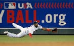 Minnesota Twins center fielder Danny Santana dives for a fly to right by Kansas City Royals' Omar Infante during the fourth inning of a baseball game 