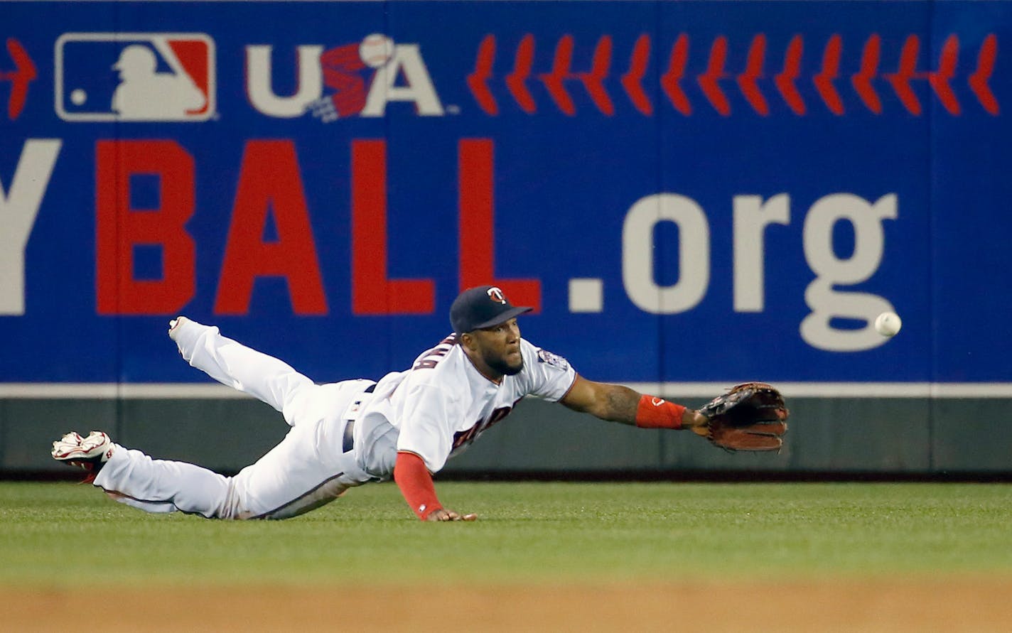 Minnesota Twins center fielder Danny Santana dives for a fly to right by Kansas City Royals' Omar Infante during the fourth inning of a baseball game in Minneapolis, Monday, May 23, 2016. The Royals won 10-4. (AP Photo/Ann Heisenfelt)