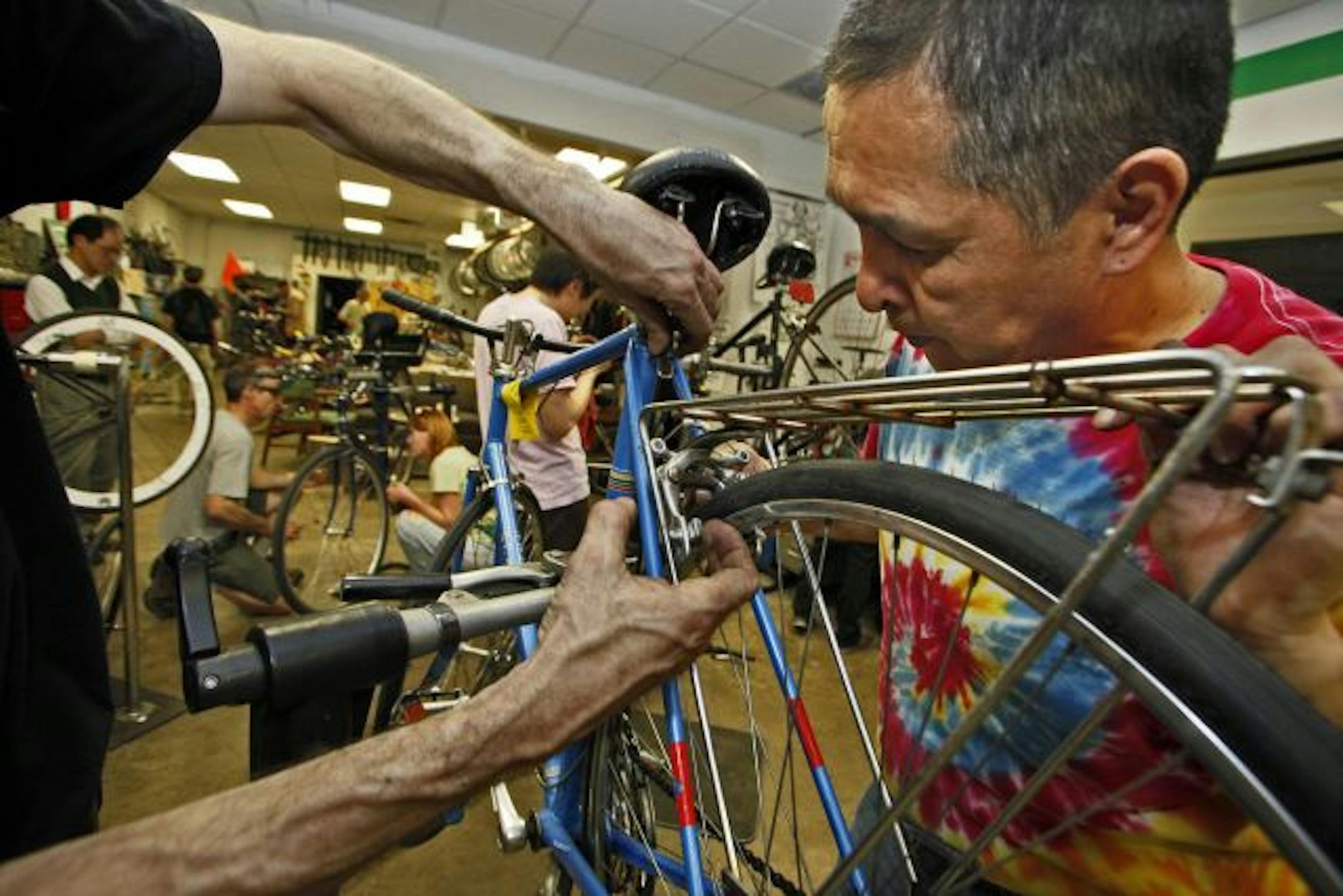 Volunteer Will Wilkins of St. Paul received some help from a staff member to repair a bike Wilkins had selected. The bike library program got a $200,000 federal grant to help it get rolling.
