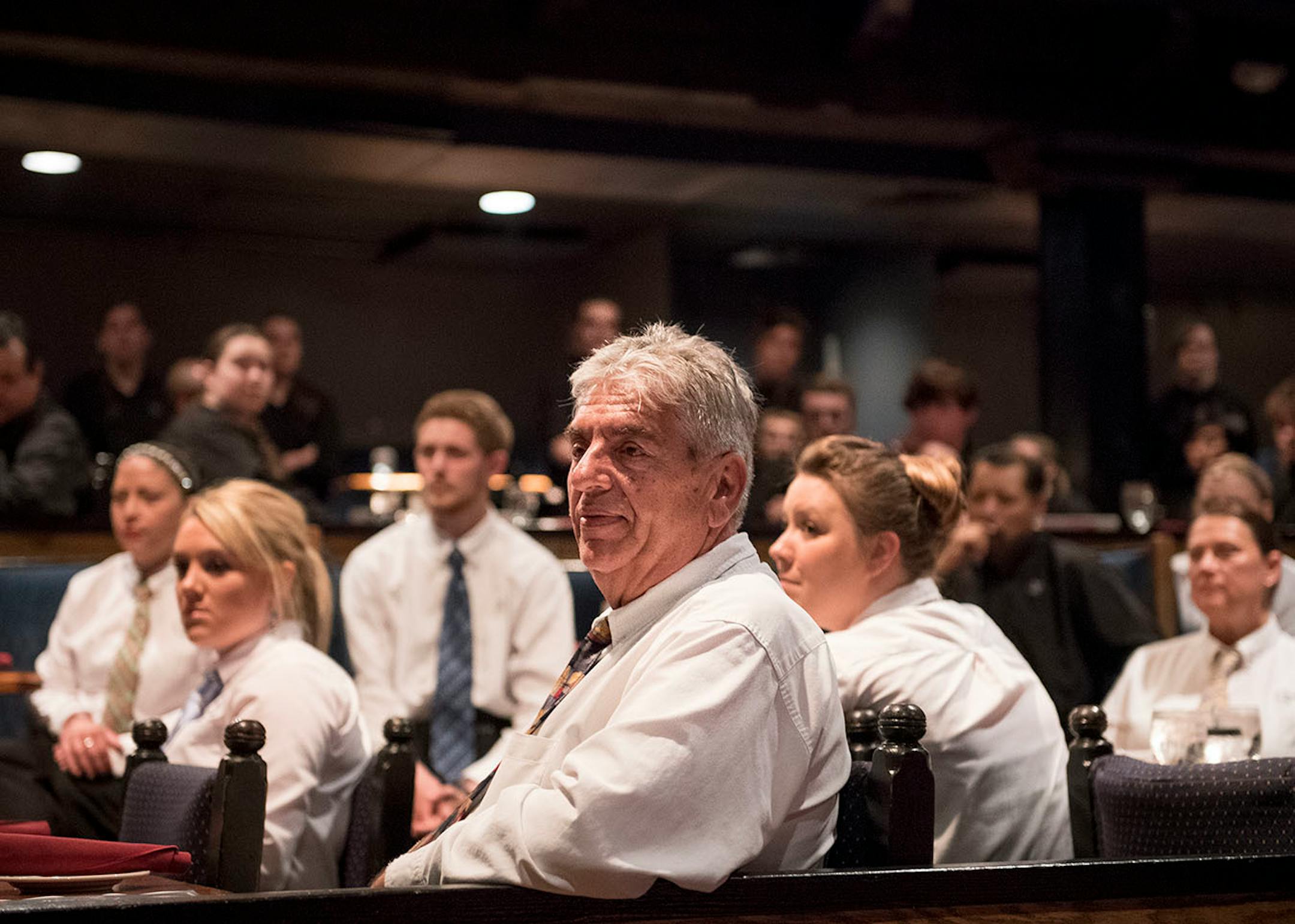 Nick Famelis, a waiter, supervisor and manager at Chanhassen Dinner Theatres, listened in during cue call, a nightly meeting where workers gather to discuss successes and failures from previous nights as well as go over a game plan for the current evening.