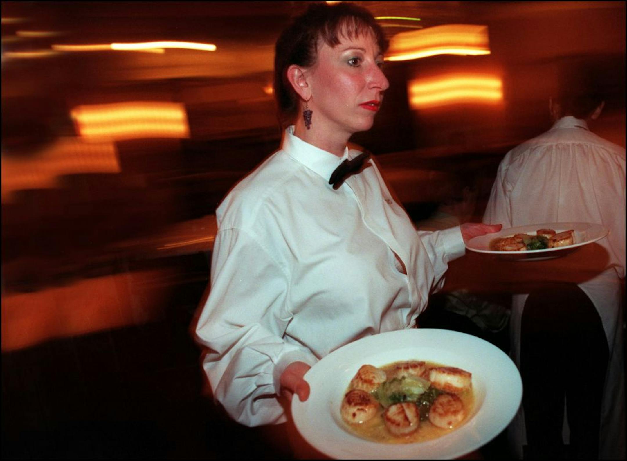 D'amico Cucina waiter, Lisa Thordarson brings out salads for her table Tuesday night. Lisa has been a waiter for six years.