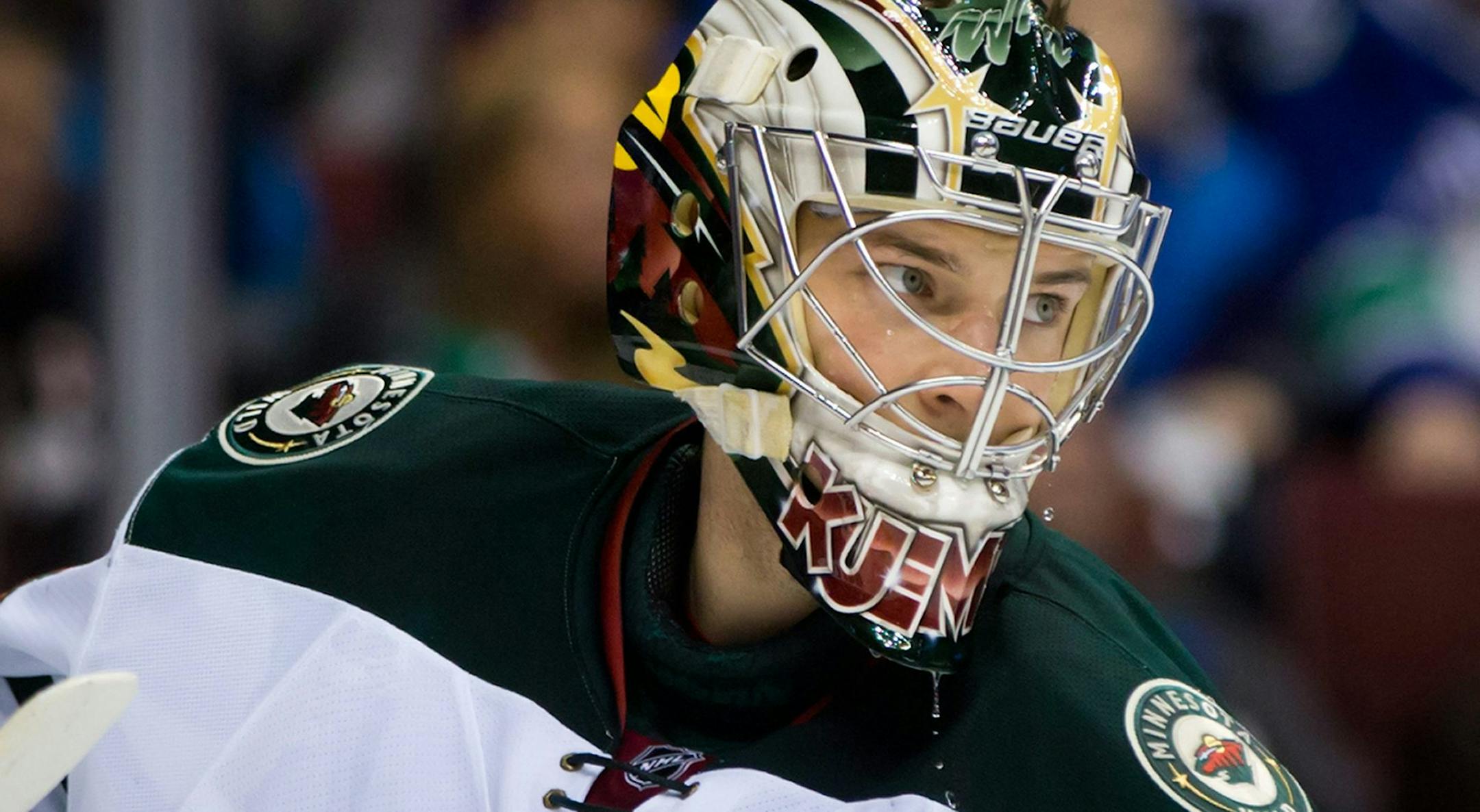 Minnesota Wild goalie Darcy Kuemper pauses during a stoppage in the first period of an NHL hockey game against the Vancouver Canucks, Friday, Feb. 28, 2014, in Vancouver, British Columbia. (AP Photo/The Canadian Press, Darryl Dyck)