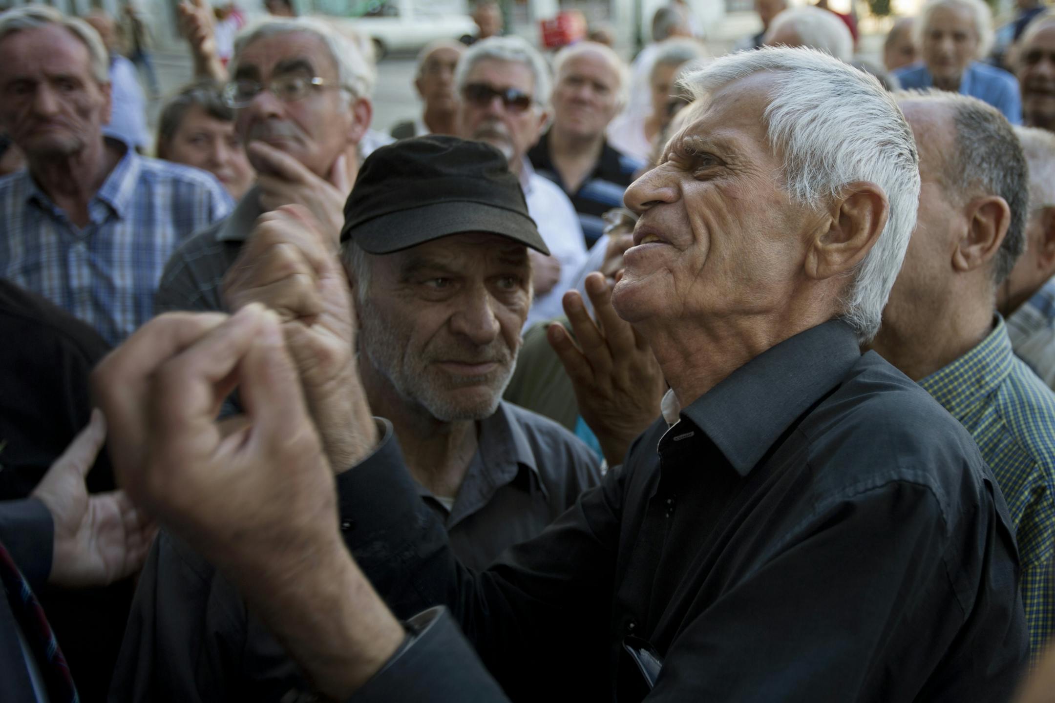 Elderly people argue with a bank worker as they wait to be allowed into the bank to withdraw a maximum of 120 euros ($134) for the week in Athens, Monday, July 6, 2015. Greece�s Finance Minister Yanis Varoufakis has resigned following Sunday�s referendum in which the majority of voters said �no� to more austerity measures in exchange for another financial bailout.