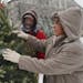 Family members Charlie Fischbach, left and Mary Johnson prepared a Christmas tree for sale on the farm that is soon to be condemed.