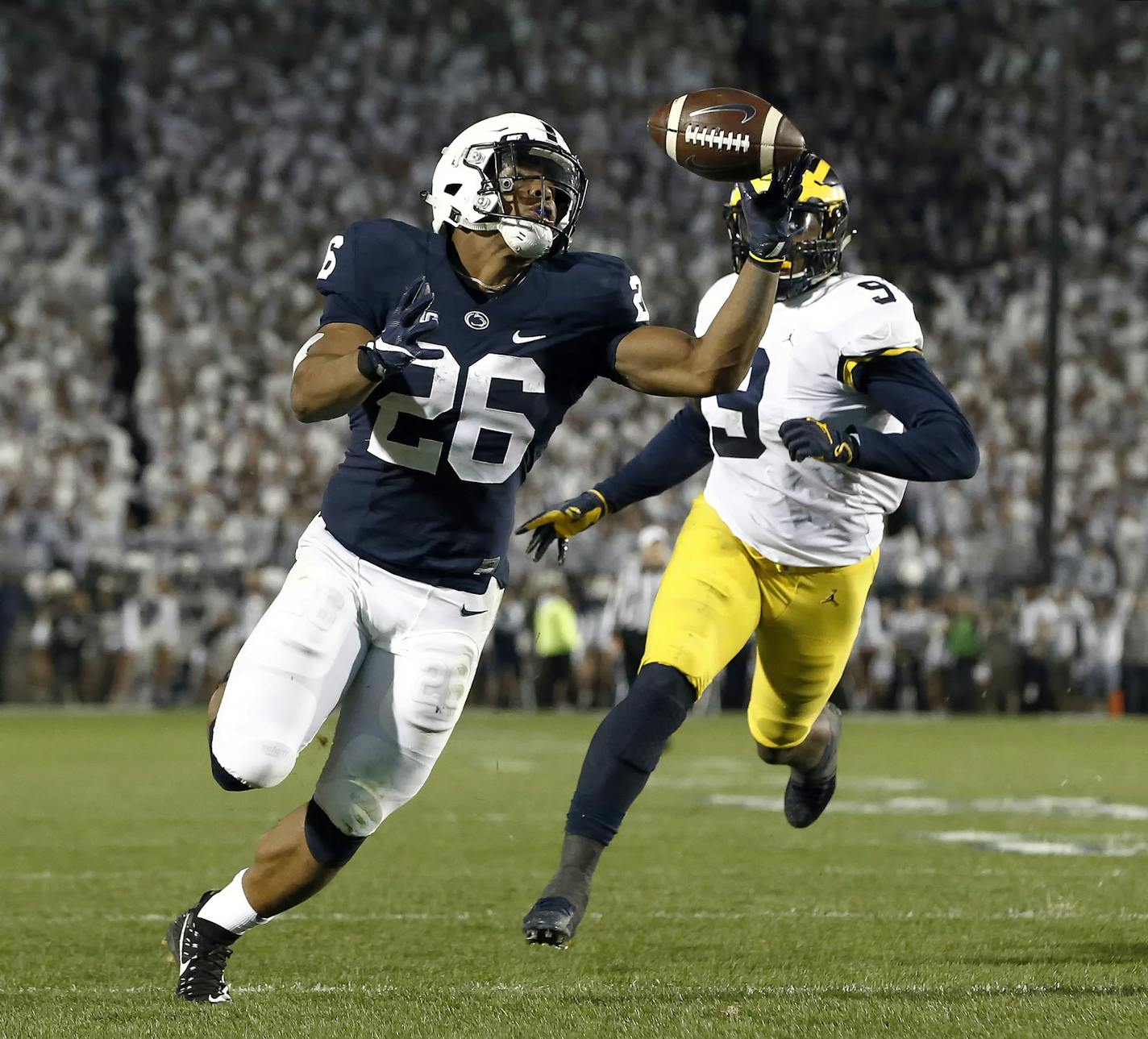 Penn State's Saquon Barkley (26) gains control of a pass and takes it in for a touchdown against Michigan during the second half of an NCAA college football game in State College, Pa., Saturday, Oct. 21, 2017. Penn State won 42-13. (AP Photo/Chris Knight)