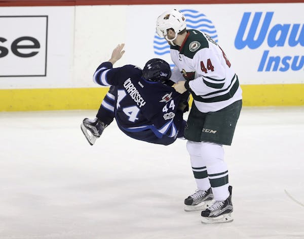 Minnesota Wild's Tyler Graovac (44) holds Winnipeg Jets' Josh Morrissey (44) by the jersey after Morrissey collided with Charlie Coyle during the thir