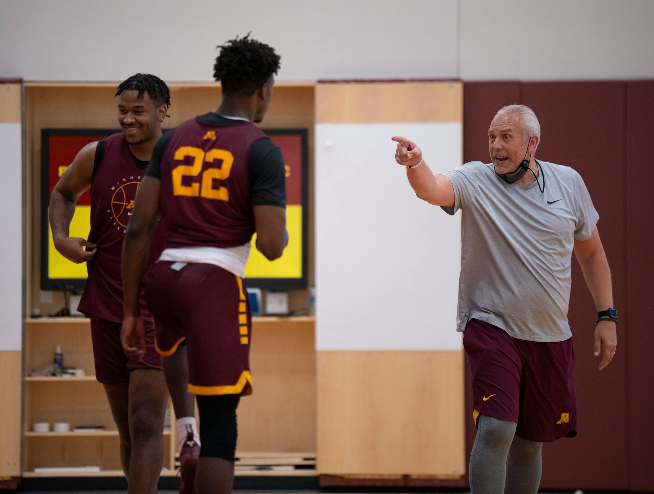 Assistant coach Dave Thorson guided forward Danny Ogele (22) during a drill he was doing with forward Eric Curry, left.