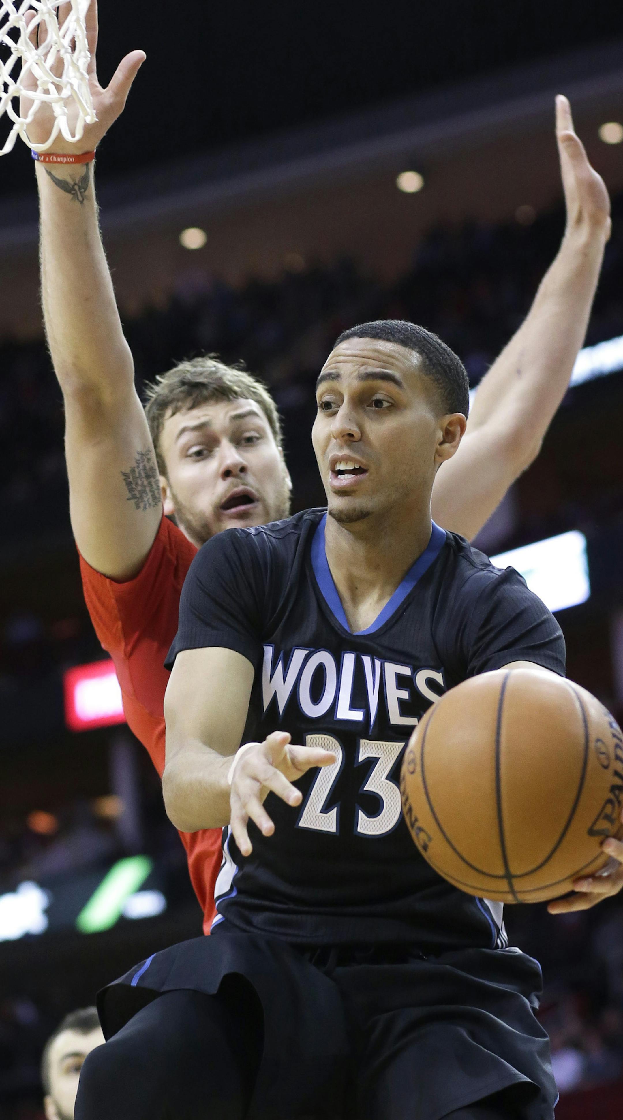 Minnesota Timberwolves' Kevin Martin (23) looks to pass the ball under pressure from Houston Rockets' Donatas Motiejunas in the first half of an NBA basketball game Monday, Feb. 23, 2015, in Houston. (AP Photo/Pat Sullivan)