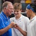 Blake head coach Ted Warner, left, congratulates Andrew Richardson, center, and Kai Chen after winning the state Class 2A doubles championship against