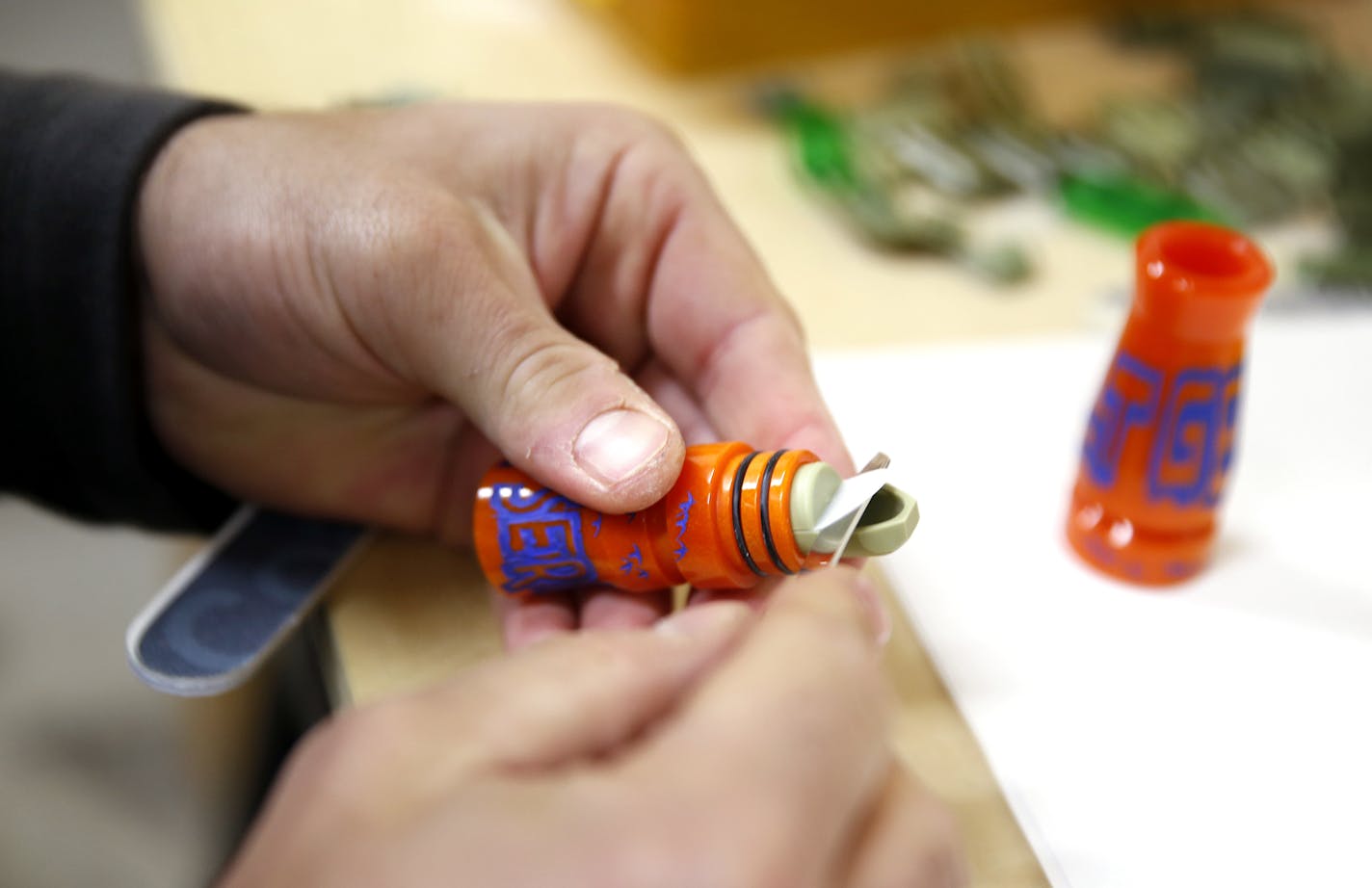 Scott Threinen makes a goose call in the headquarters of Molt Gear in Rochester, Minn.