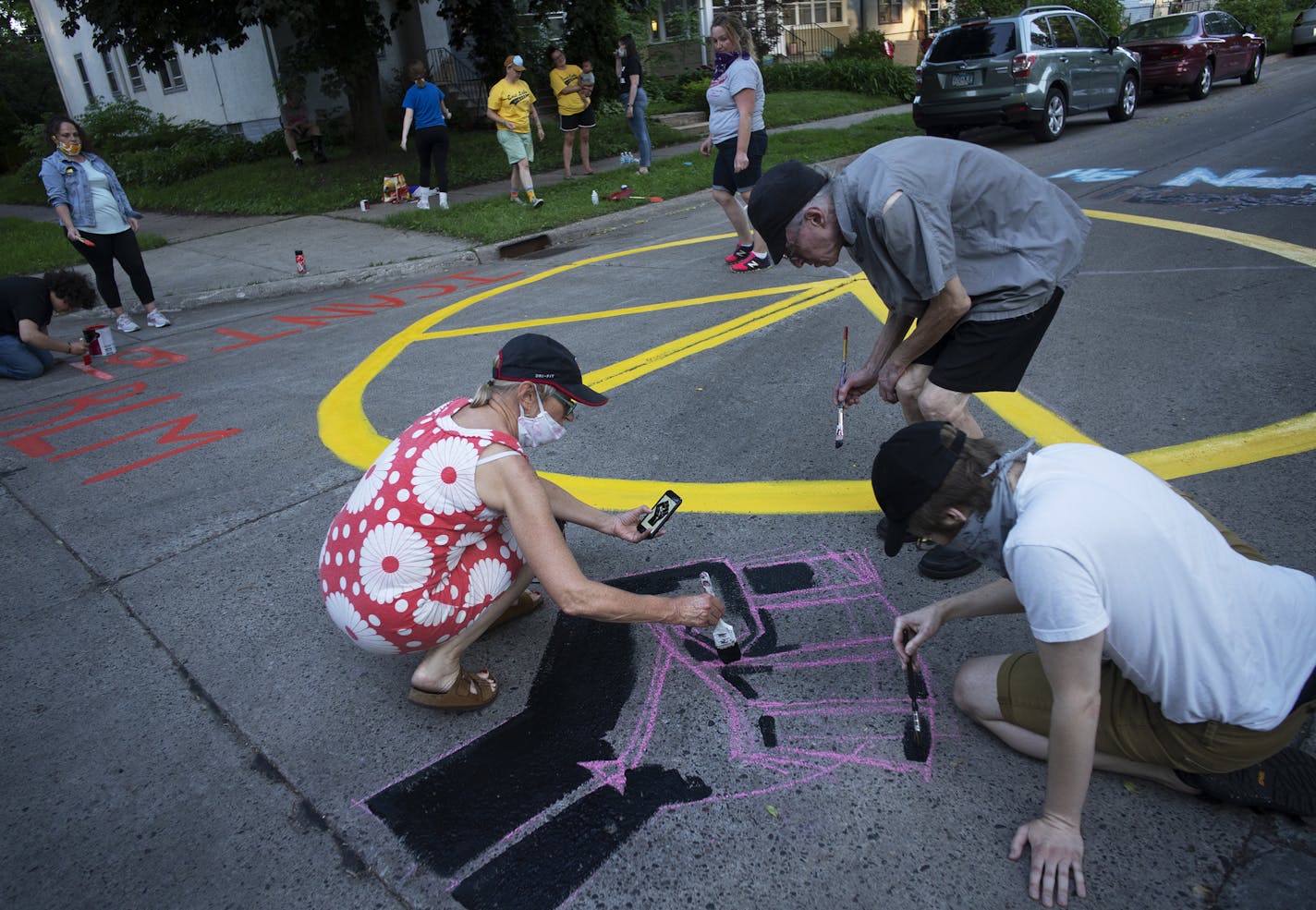 Anne Thompson helps paint a mural on their block intersection to remember what they just went through.] Residents off Lake Street in Longfellow have organized block meetings the last few days to plan out block patrols, vote on whether to barricade their street and discuss how best to communicate with one another. Anne Thompson and Madeline Clive are two of the women who have led the effort. Each night when curfew hits, Clive sits outside with her pitchfork nearby and a whistle, watching for any