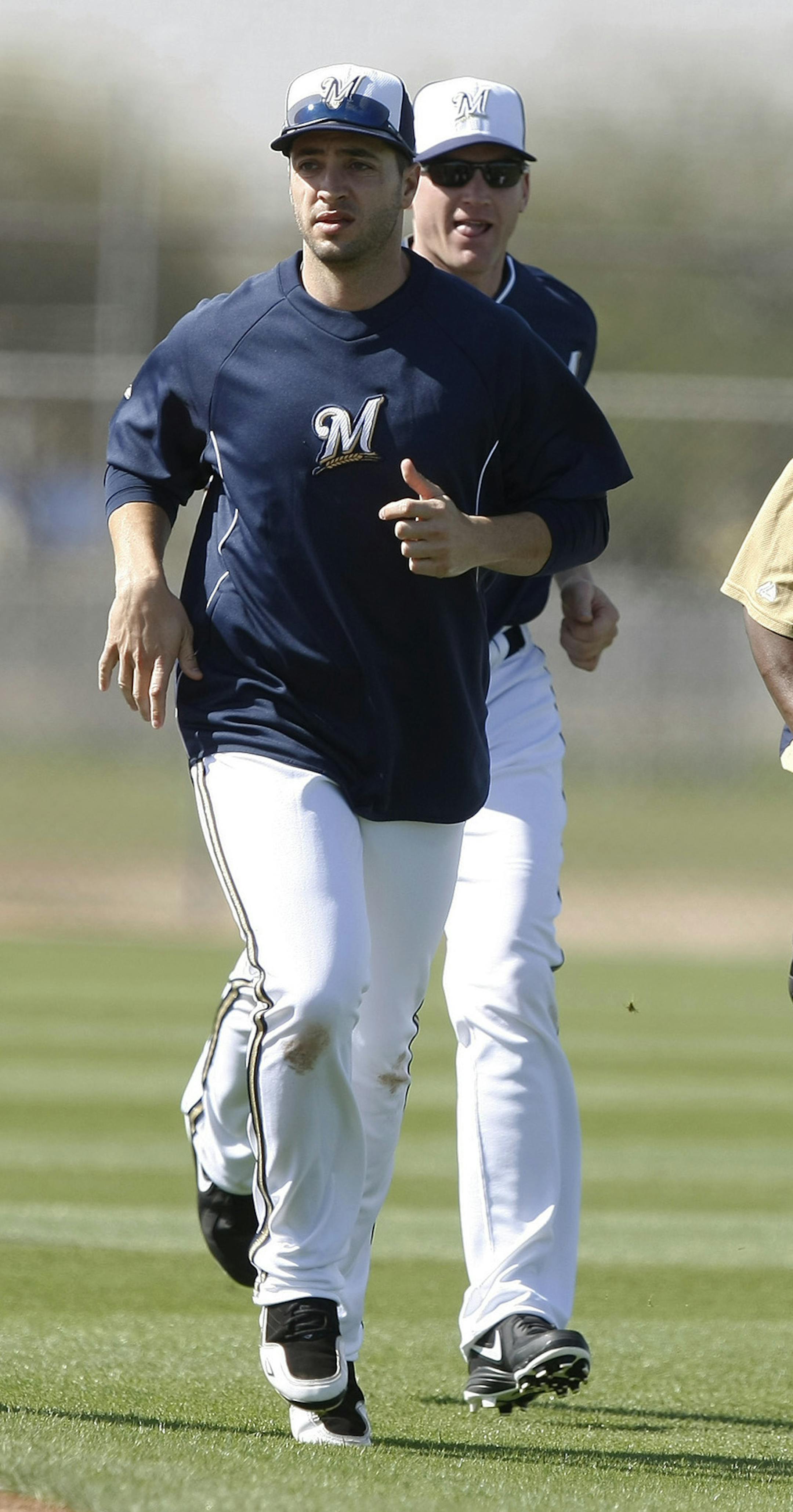 Milwaukee Brewers' Ryan Braun, second from left, and Rickie Weeks (23) lead running drills during baseball spring training Saturday, Feb. 22, 2014, in Phoenix. (AP Photo/Rick Scuteri)