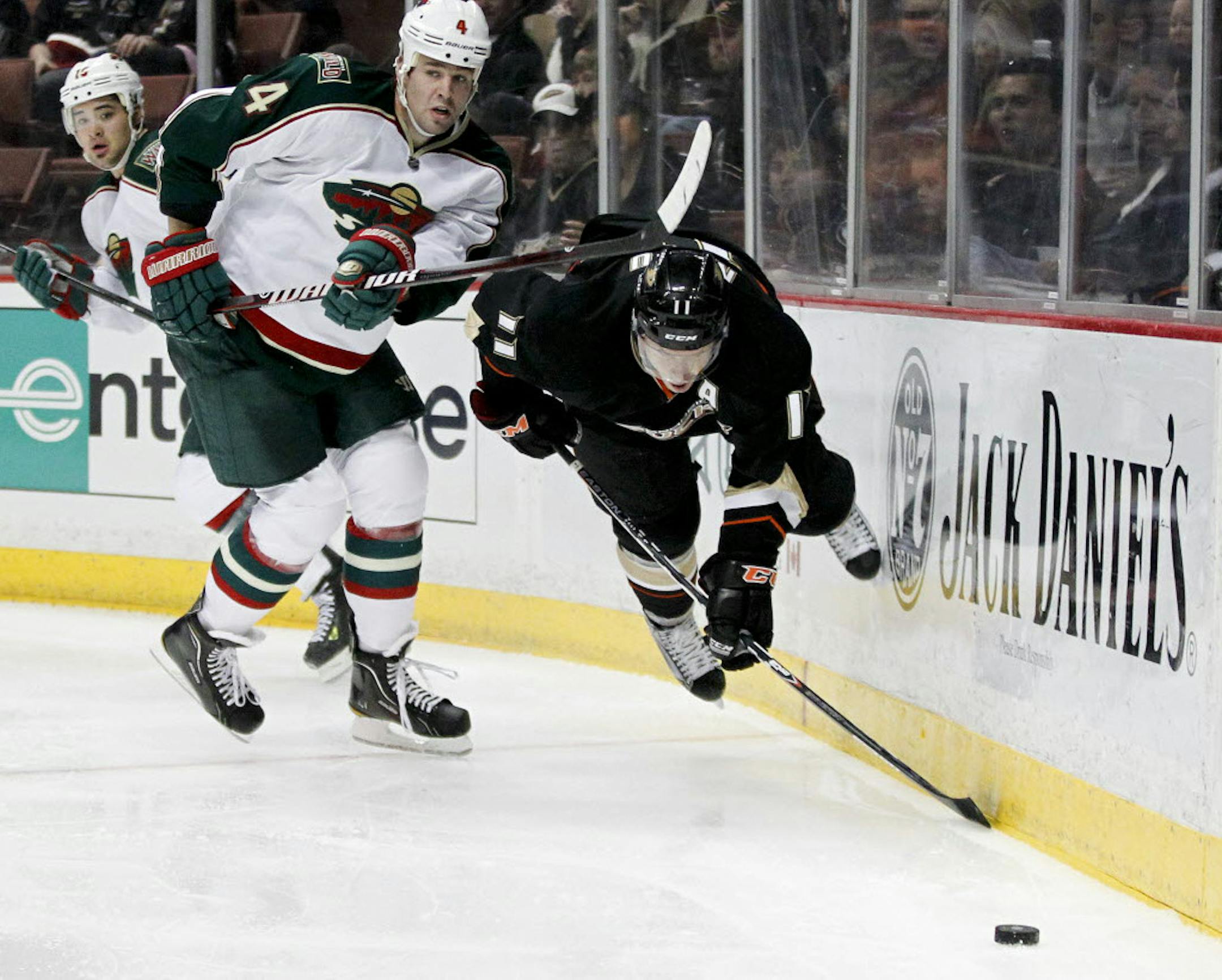 Minnesota's Clayton Stoner, left, battles Anaheim's Saku Koivu for the puck.