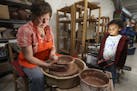 Here, Artist Karin Kraemer, owner of Duluth Pottery, works on a new piece under the watchful eye of Amaya St. John, 4, of Duluth during their open hou