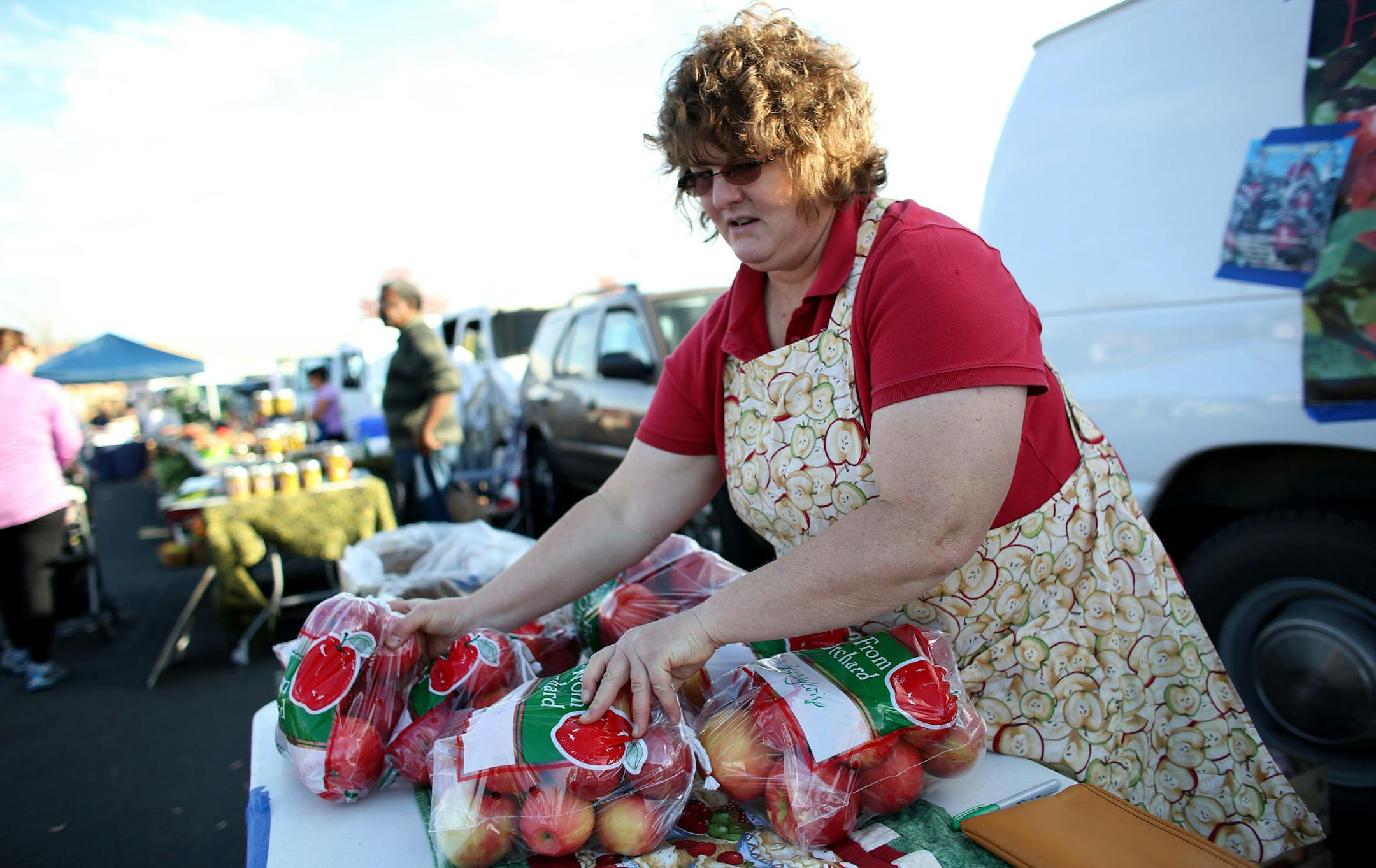 Barbara Thompson, of Hillcrest Orchard restocked her display with a new bag of apples. ] (KYNDELL HARKNESS/STAR TRIBUNE) kyndell.harkness@startribune.com At the Maple Grove farmers' market inMaple Grove Min., Thursday, October 16, 2014.