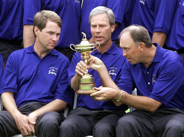 Davis Love III, captain Ben Crenshaw and Tom Lehman took a close look at the Ryder Cup trophy during their team picture at The Country Club in Brookli
