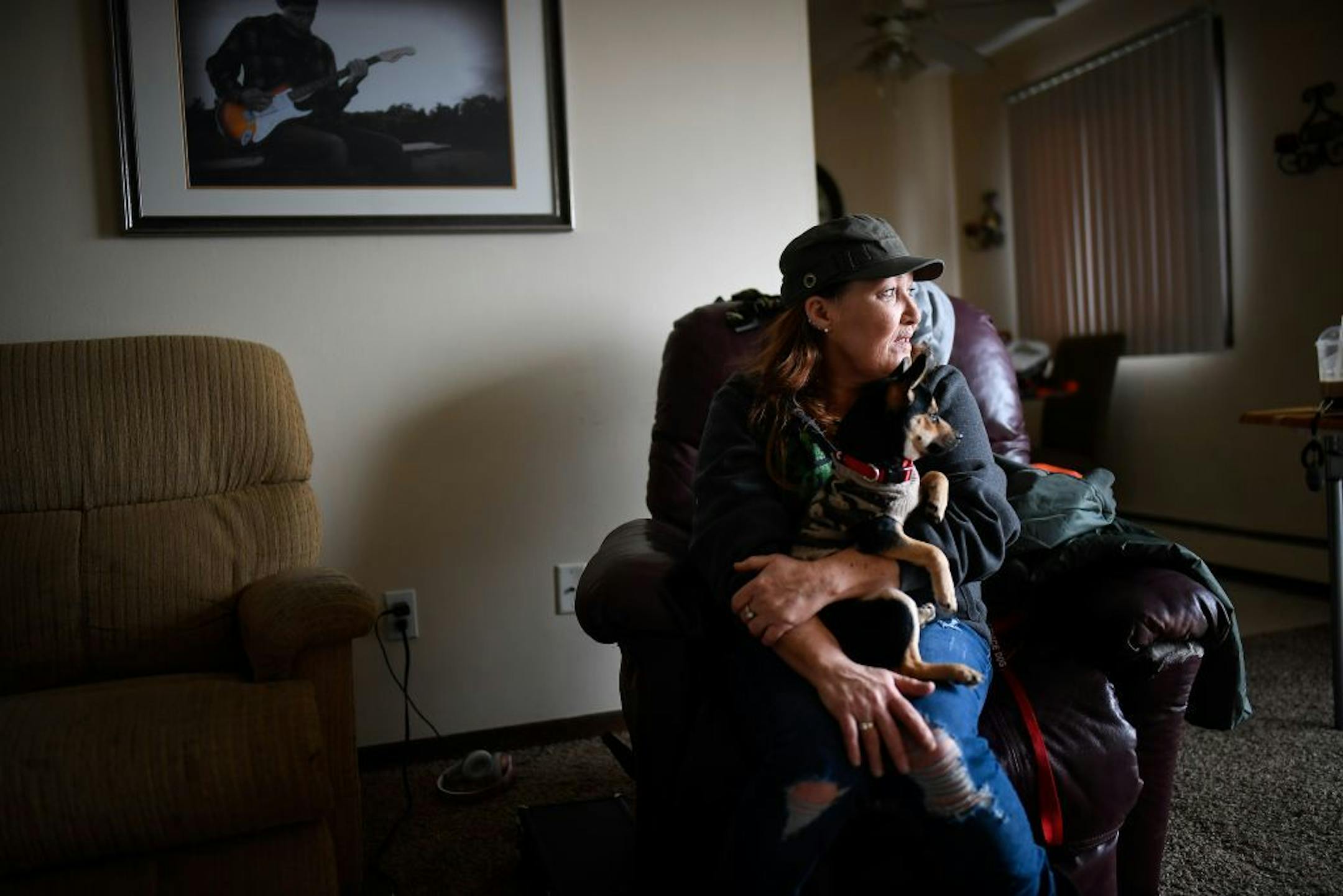 Kristine Brown looked on while holding her 6-month old puppy, Harley, in her living room Saturday. She's one of the dozens of tenants facing eviction from their apartment building in Osseo.
