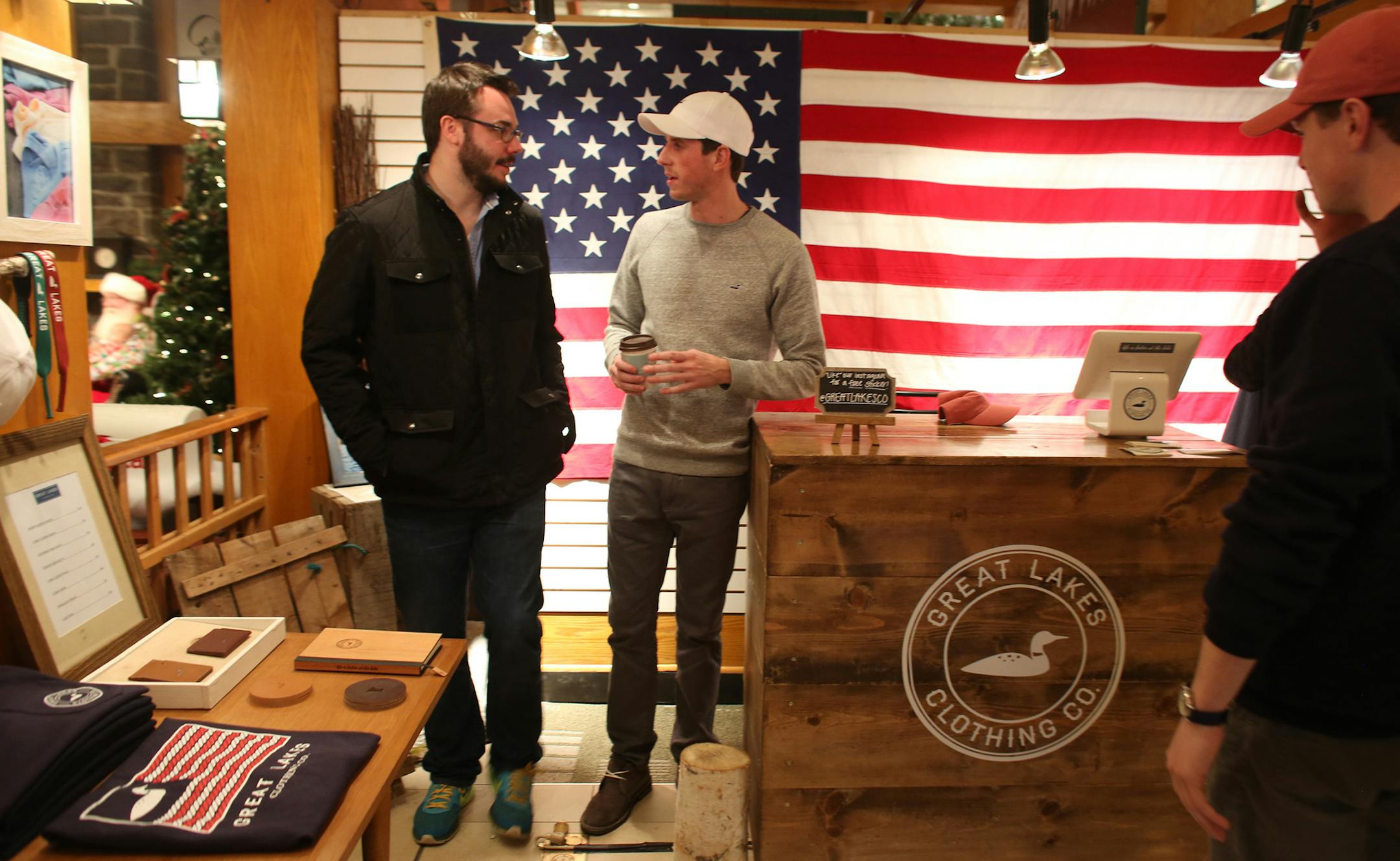 Spencer Barrett, co owner of Great Lakes Clothing Co.,chatted with customer Dominic Sisley at their kiosk in Ridgedale Mall. ] (KYNDELL HARKNESS/STAR TRIBUNE) kyndell.harkness@startribune.com Ridgedale Mall in Minnetonka , Min., Friday, December 5, 2014.