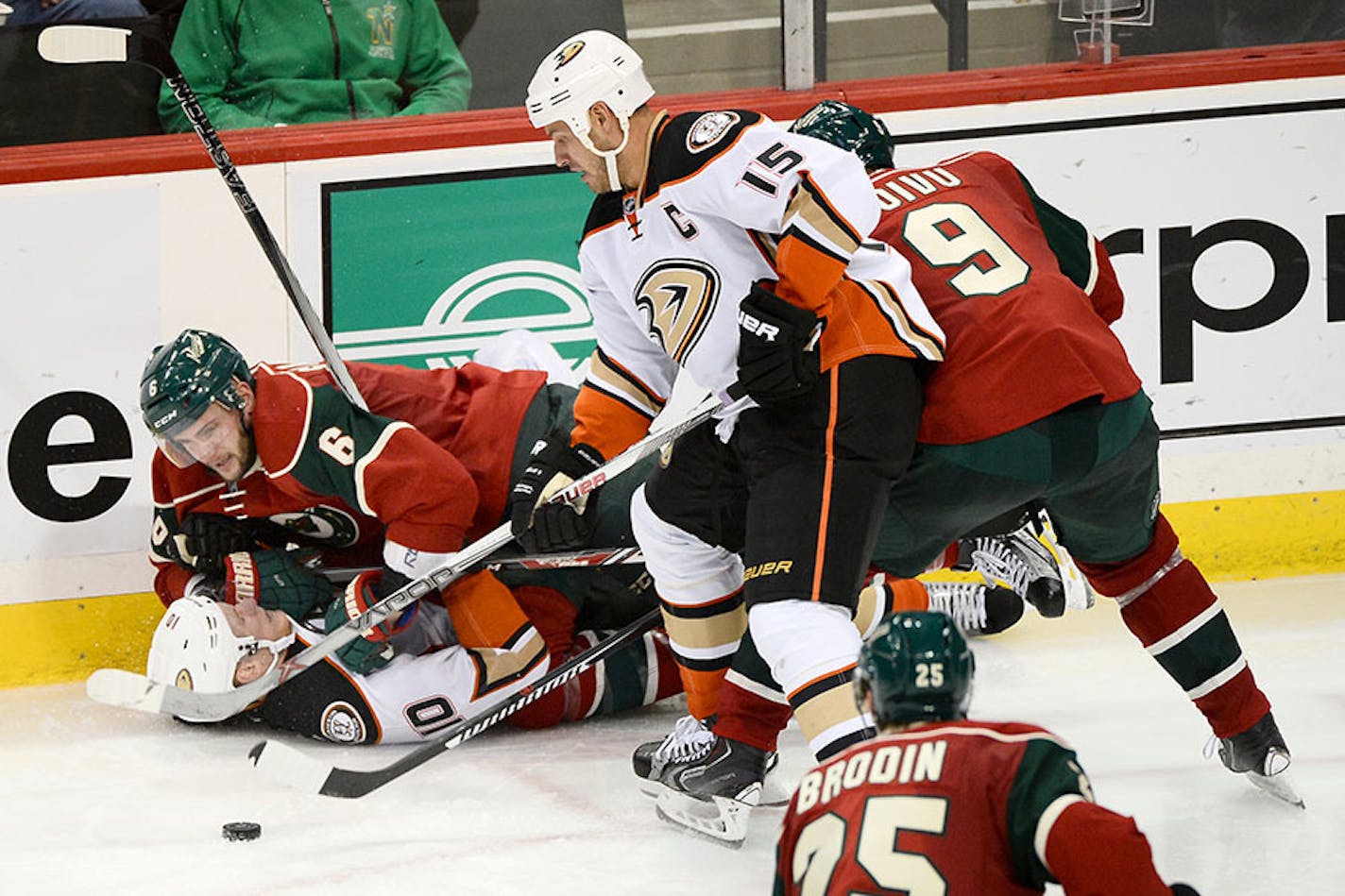 Anaheim Ducks right wing Corey Perry (10) was pinned down to the ice by Minnesota Wild defenseman Marco Scandella (6) as Anaheim Ducks center Ryan Getzlaf (15) and Minnesota Wild center Mikko Koivu (9) battled for the puck in the third period.