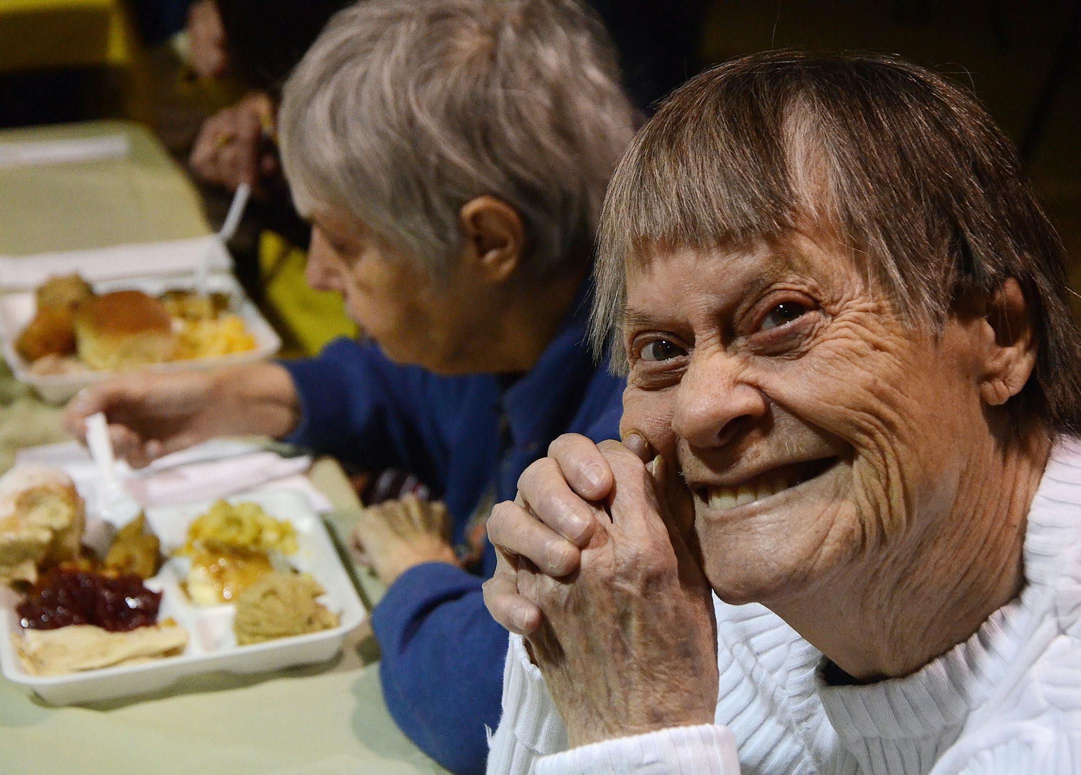 Patricia Cole smiles as she waits for her Thanksgiving dinner at Washington Heights United Methodist Church, Thursday, Nov. 27, 2014, in Battle Creek, Mich. (AP Photo/The Enquirer, John Grap) NO SALES