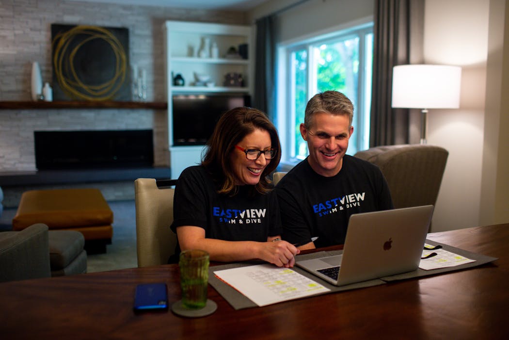 Jennie and Todd Lee watched from Apple Valley home as their their daughters competed for Eastview in a socially distanced swim meet while it was live streamed on YouTube on Friday.