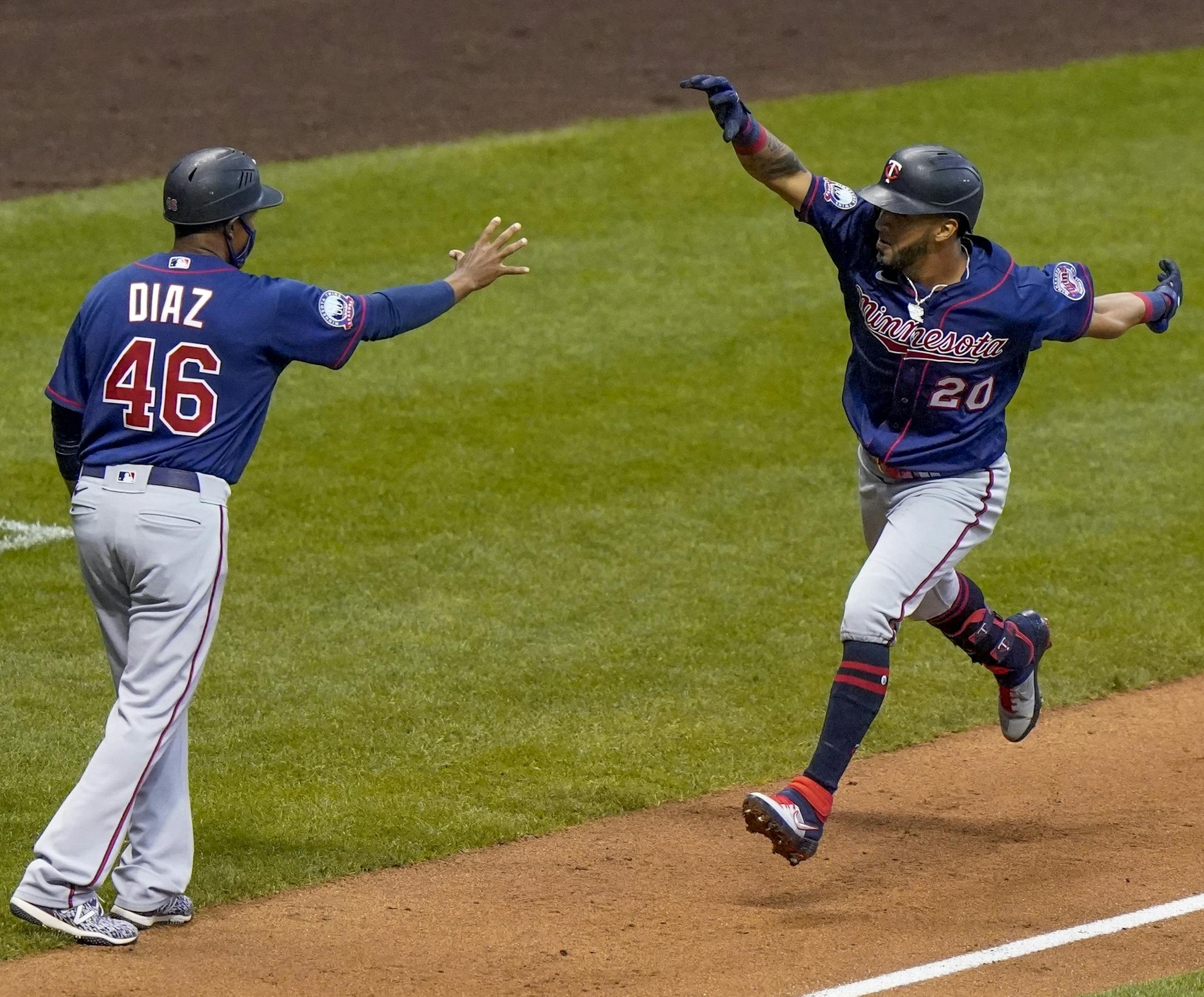 Minnesota Twins' Eddie Rosario celebrates his grand slam with third base coach Tony Diaz during the third inning of a baseball game against the Milwaukee Brewers Monday, Aug. 10, 2020, in Milwaukee. (AP Photo/Morry Gash)