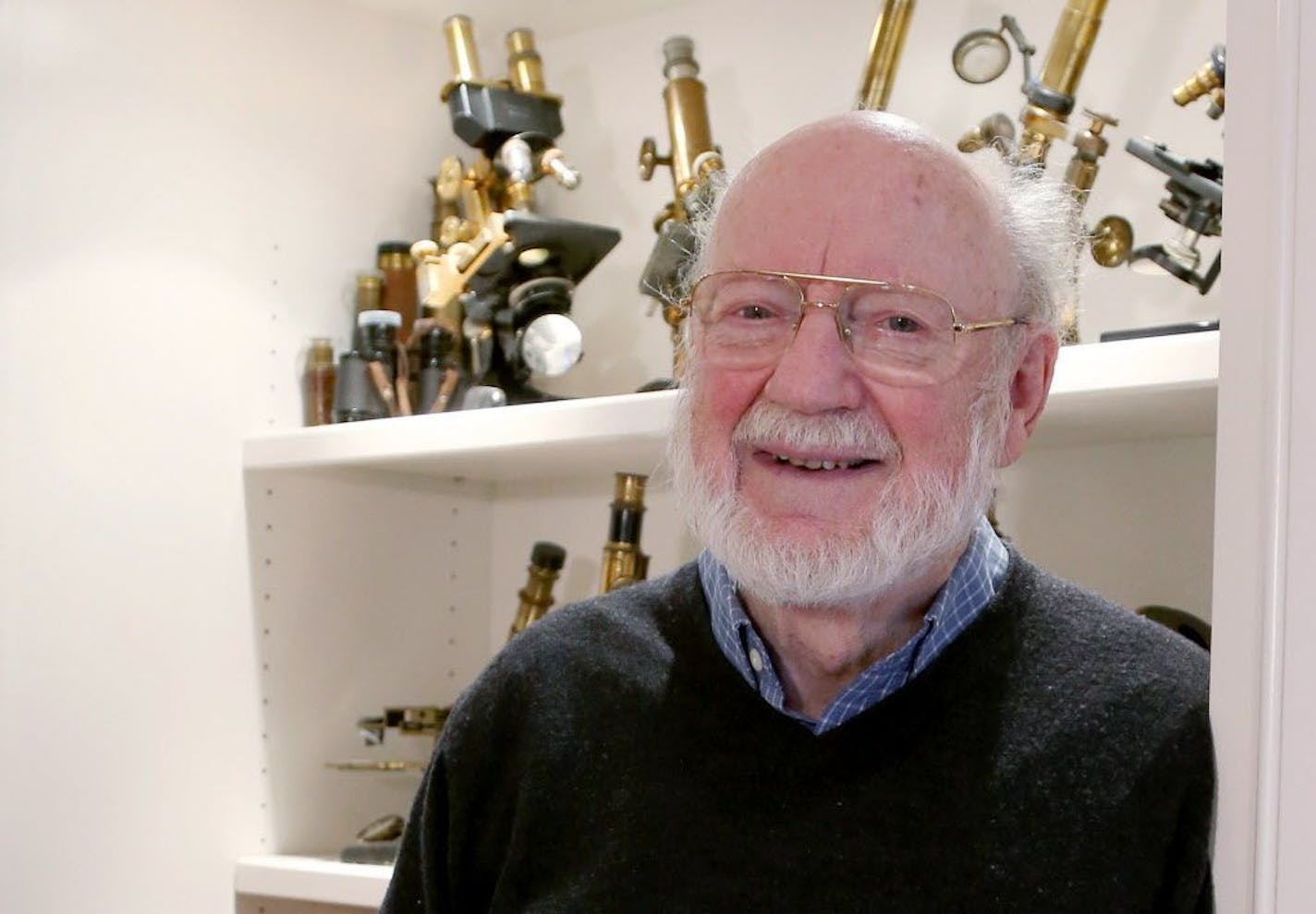 Scientist William C. Campbell poses for a photo with a collection of microscopes in his home in North Andover, Mass., Monday, Oct. 5, 2015. Campbell is one of three scientists from the U.S., Japan and China who won the Nobel Prize in medicine on Monday for discovering drugs to fight malaria and other tropical diseases that affect hundreds of millions of people every year.