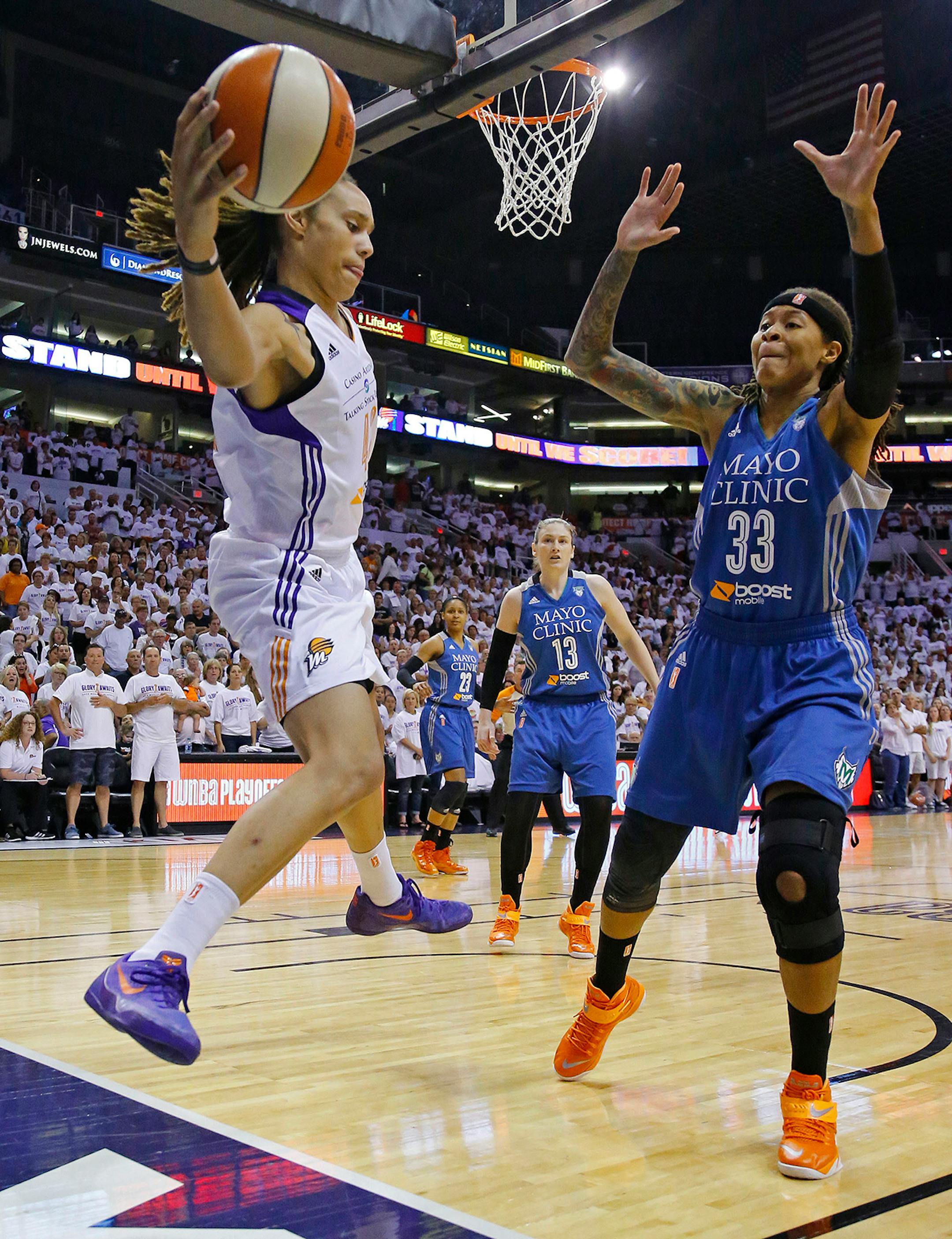 Phoenix Mercury center Brittney Griner (42) tries to keep the ball in bounds against Minnesota Lynx guard Seimone Augustus (33) during the first quarter of Game 1 of the WNBA Western Conference finals Friday, Aug. 29, 2014 in Phoenix, Ariz.