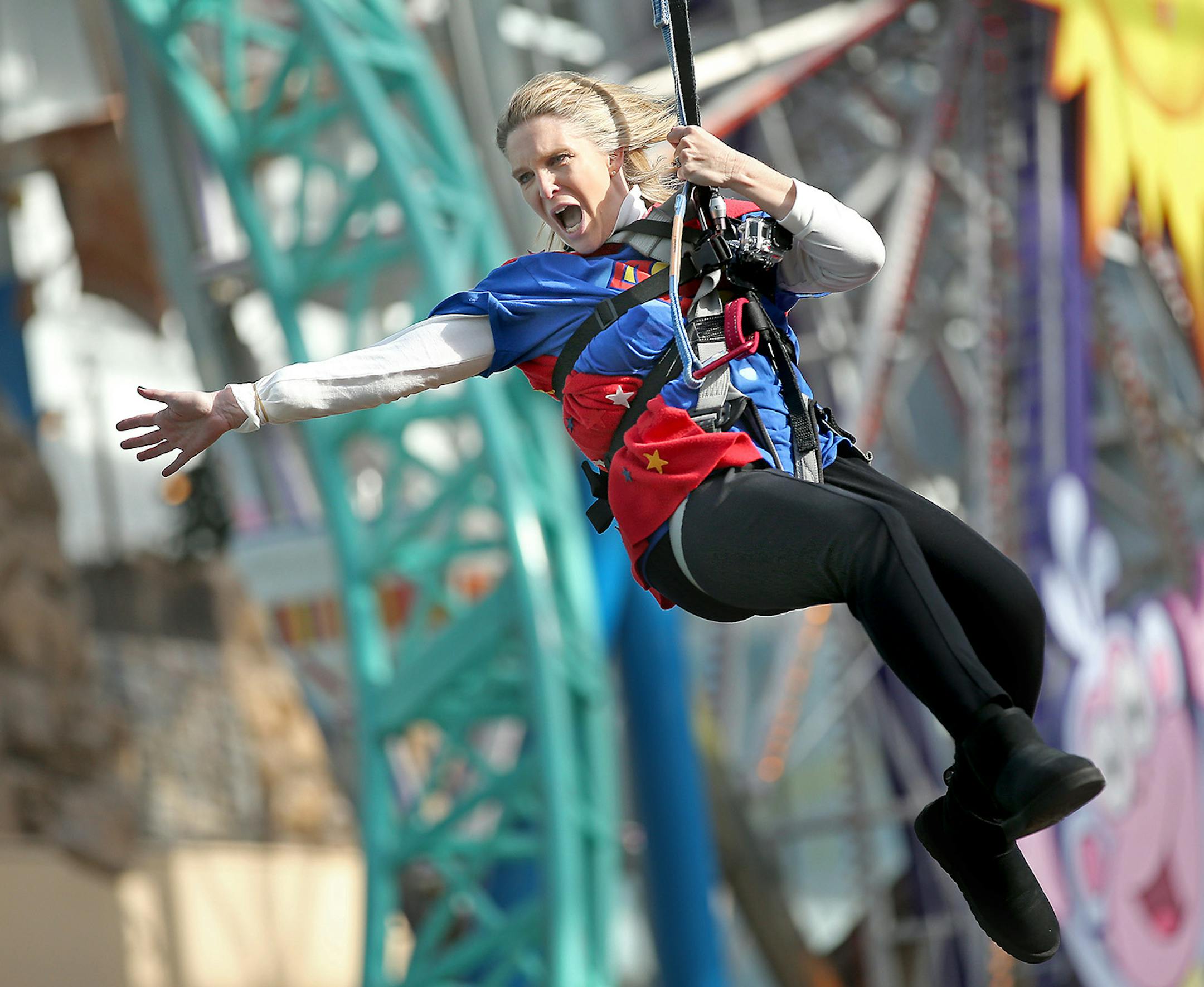 Dressed as a super hero, Hilltop Elementary School's Sue Vallafskey swung high above her students on the Mall of America's Zip Line, Thursday, November 13, 2014 in Bloomington, MN. Vallafskey joined other school principals and teachers to gain awareness for "Give to the Max" day, the annual giving extravaganza that raised $17 million in 24 hours last year. ] (ELIZABETH FLORES/STAR TRIBUNE) ELIZABETH FLORES &#x2022; eflores@startribune.com