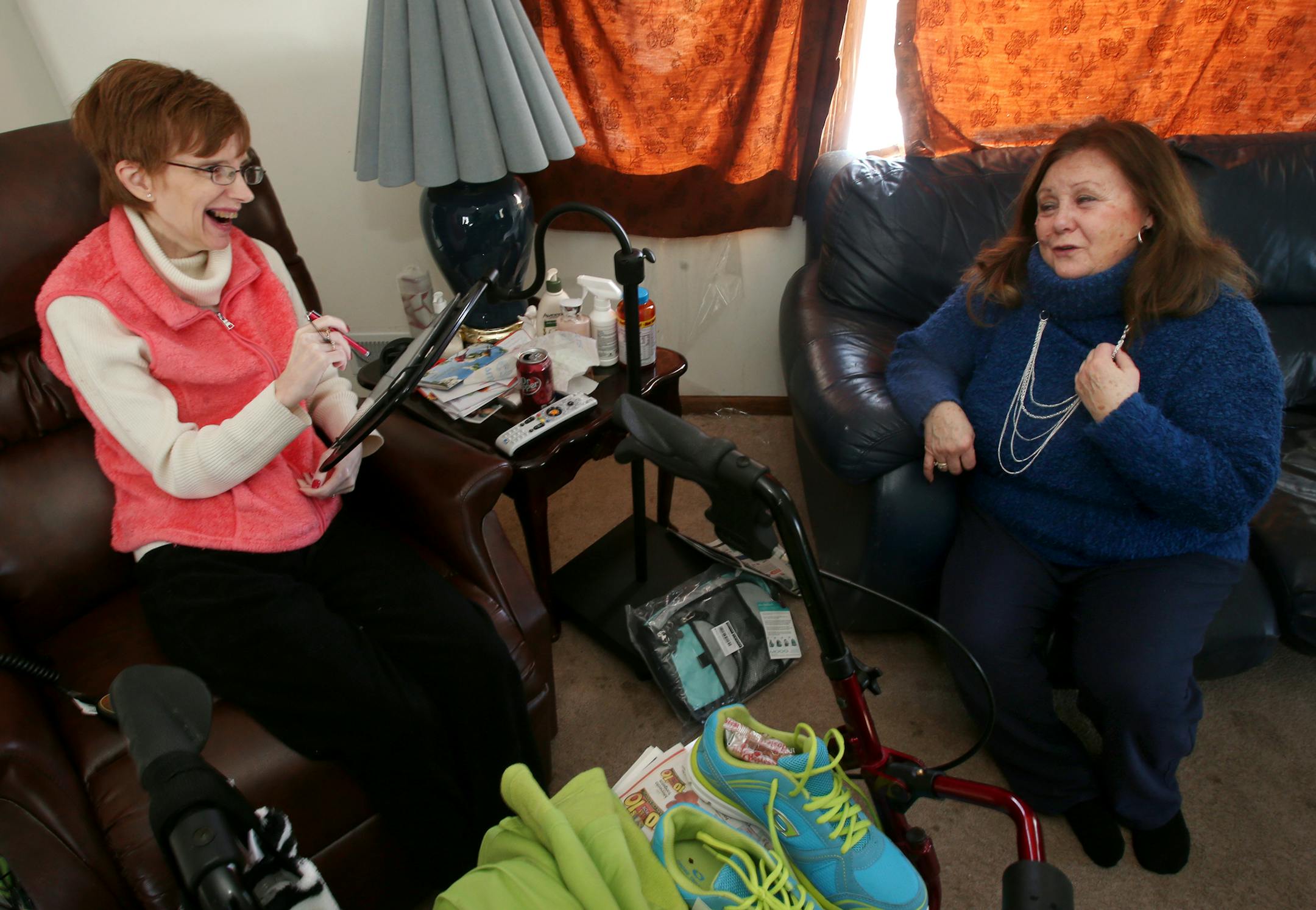 Jan Rickdeil (left) plays with her Ipad and shares a laugh with Barb Ottness, a volunteer with the Tamarisk organization, Barb Ottness visits Jan Rickdeil, a woman with ALS at her home in Cedar, MN. February 6, 2014. ] JOELKOYAMA‚Ä¢jkoyama@startribune Barb Ottness, a volunteer with the Tamarisk organization, will be visiting Jan Rickdeil, a woman with ALS who is helped by Ottness.