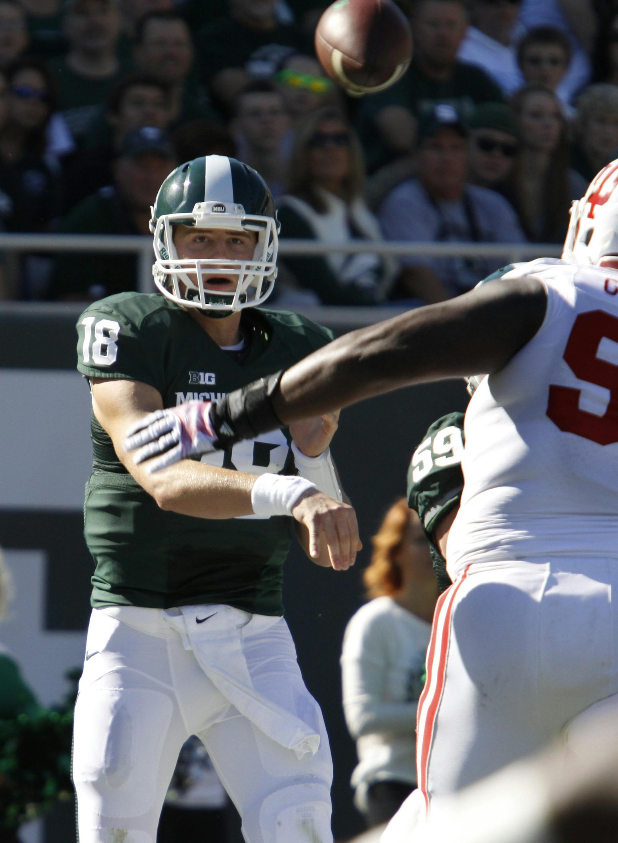 Michigan State quarterback Connor Cook (18) throws a pass over Indiana's Ralphael Green during the first quarter of an NCAA college football game, Saturday, Oct. 12, 2013, in East Lansing, Mich. Michigan State won 42-28. (AP Photo/Al Goldis) ORG XMIT: ELJ110
