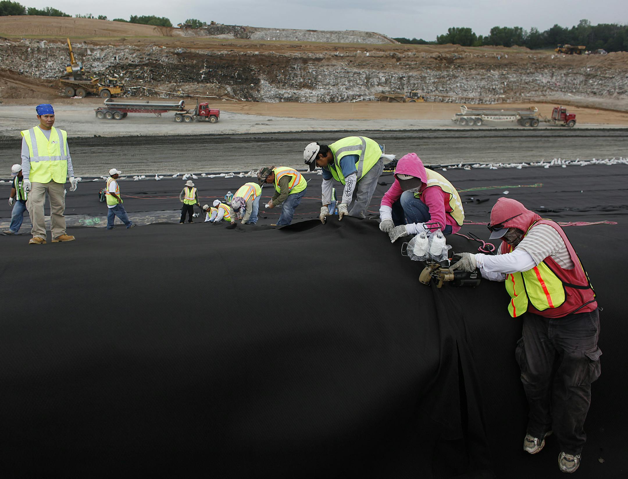 JERRY HOLT •jgholt@startribune.com 7/27/09----County Landfill---] Workers stretched a new liner in section of the old the Washington County landfill in Lake Elmo. In a $25 million job contractors are unearthing trash in Lake Elmo that hasn’t seen the light of day for the more then three decades. Their mission is to extract hazardous 3m wastes that are a source of ground water pollution, and then re-bury the rest of garbage.