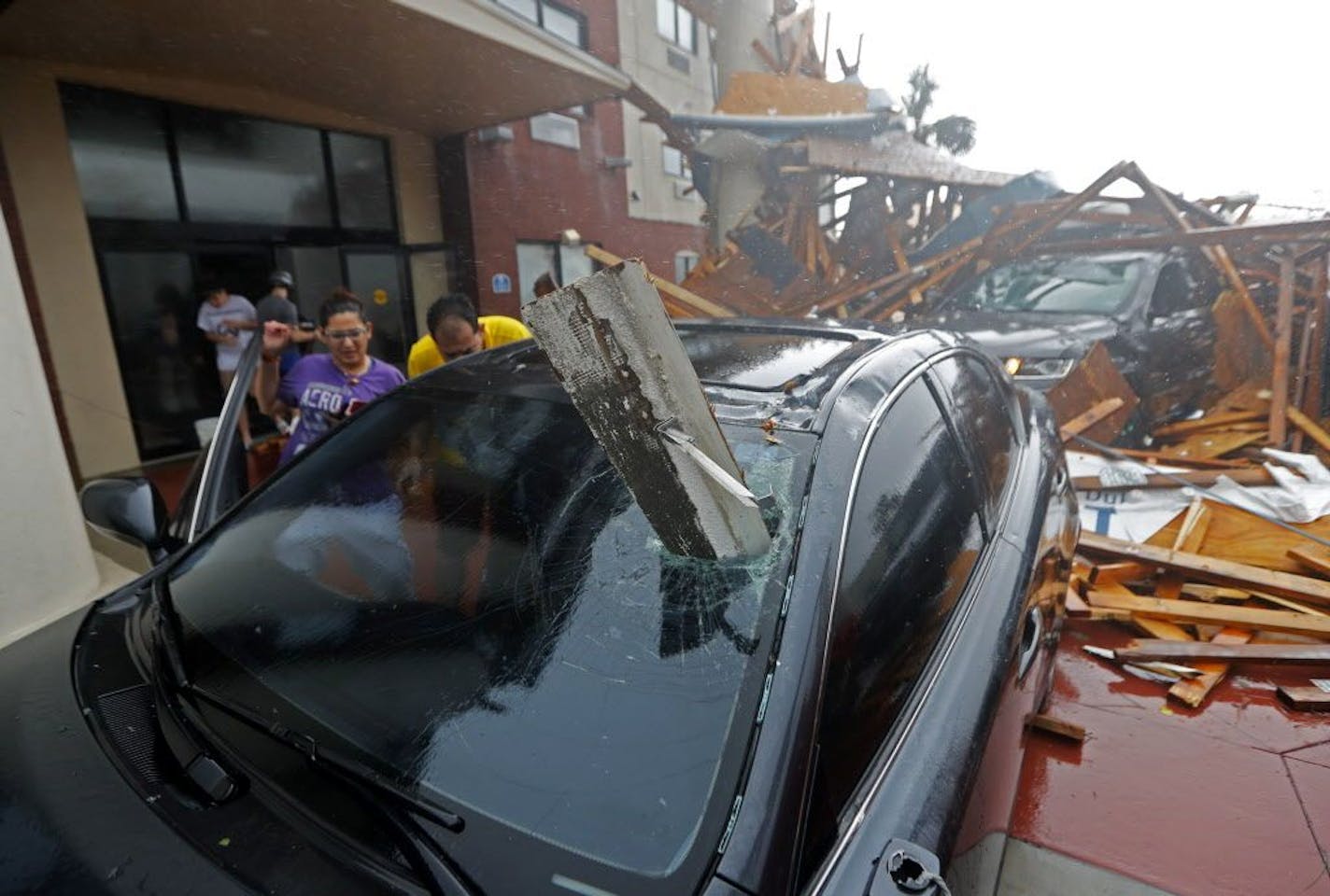 A woman checks on her vehicle as Hurricane Michael passes through, after the hotel canopy had just collapsed, in Panama City Beach, Fla., Wednesday, Oct. 10, 2018.