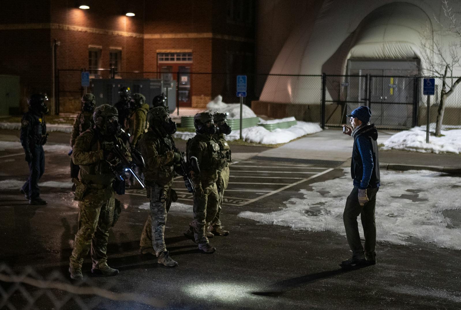 A protester documents federal agents as they take someone into custody outside of the Whipple Federal Building on Monday, Jan. 12.