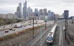 An Amtrak train departs 30th Street Station moving parallel to motor vehicle traffic on Interstate 76 in Philadelphia, Wednesday, March 31, 2021. Look