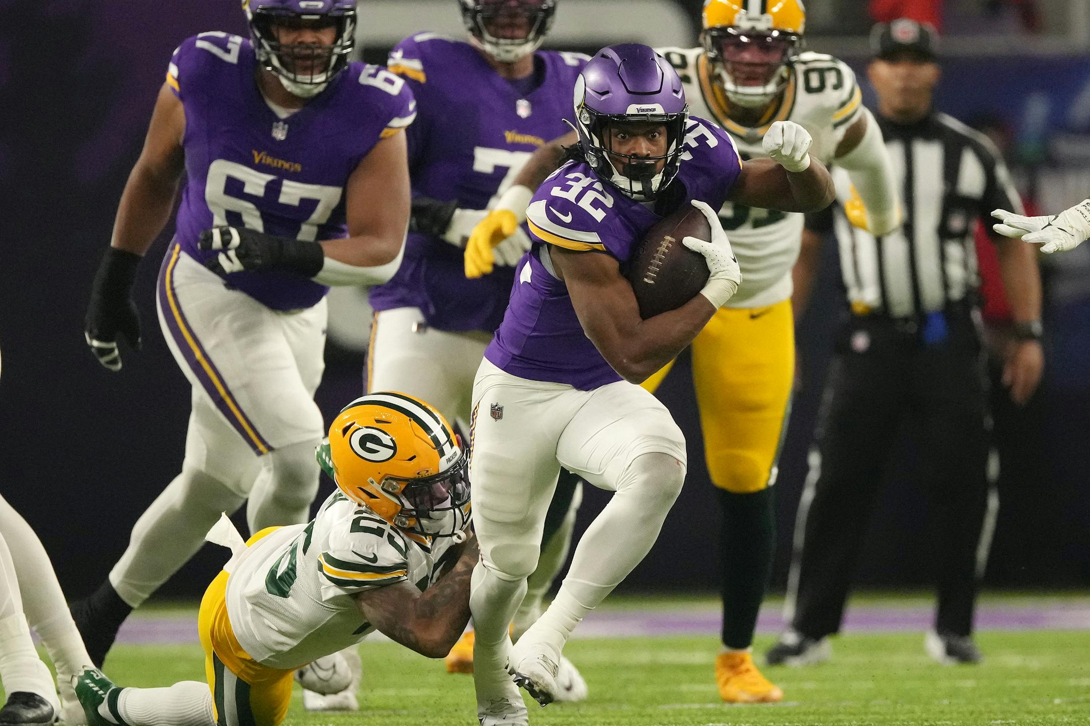 Minnesota Vikings running back Ty Chandler (32) rushes the ball as Green Bay Packers cornerback Keisean Nixon (25) gets ahold of his jersey in the first quarter of an NFL game between the Minnesota Vikings and the Green Bay Packers Sunday, Dec. 31, 2023 at U.S. Bank Stadium in Minneapolis. ] ANTHONY SOUFFLE • anthony.souffle@startribune.com