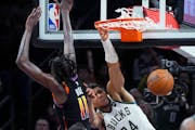 Milwaukee Bucks forward Giannis Antetokounmpo, right, dunks against Phoenix Suns center Bol Bol during the second half of an NBA basketball game Tuesd